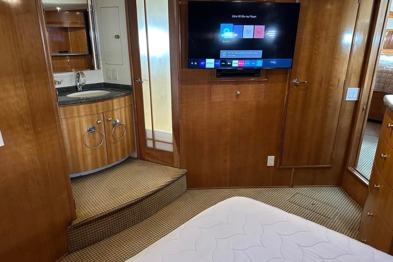 Interior of 2000 Carver 530 Voyager Pilothouse with TV, sink, and wooden cabinetry.