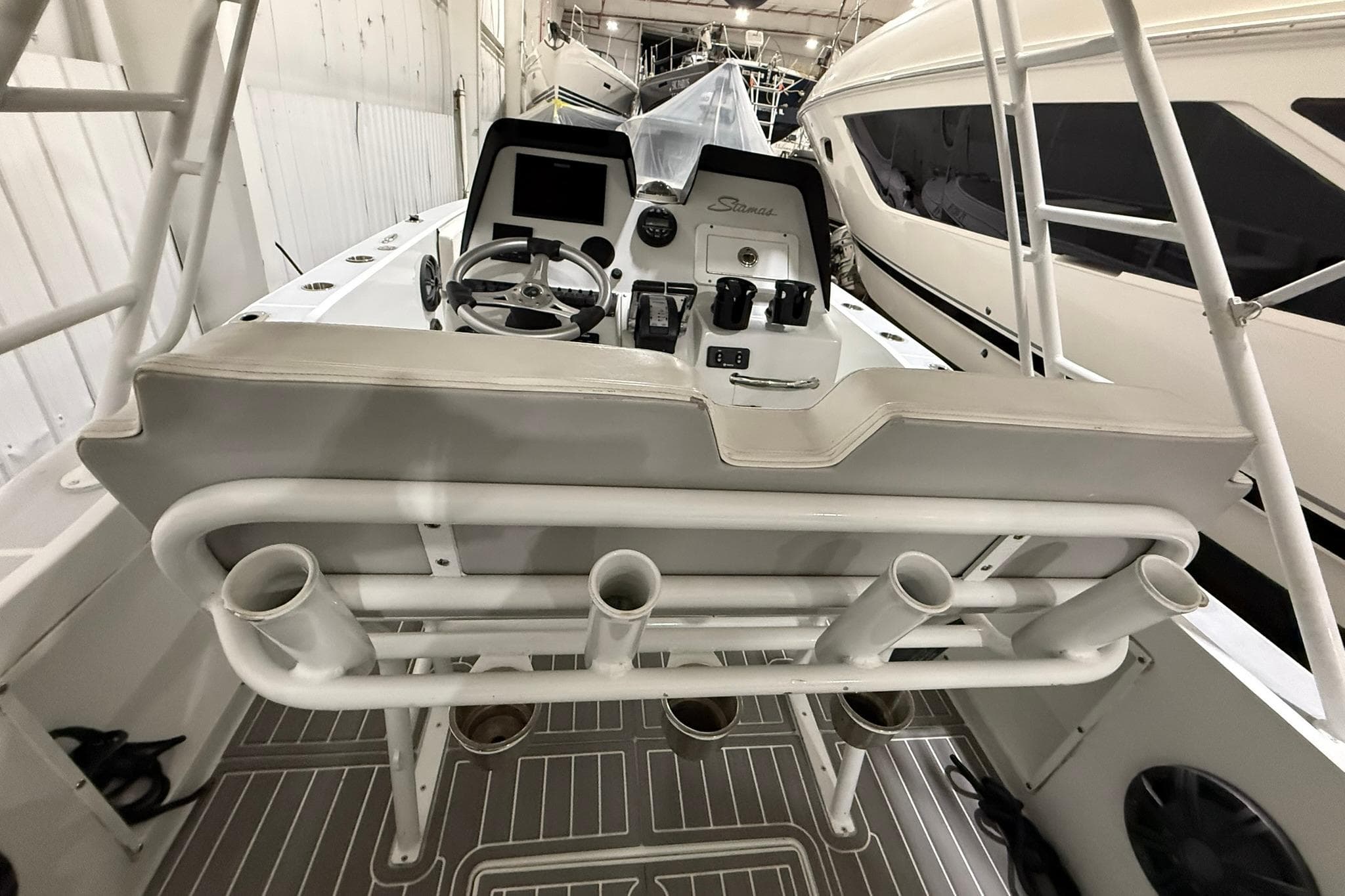 1988 Stamas 255 Tarpon boat cockpit with steering wheel and rod holders.