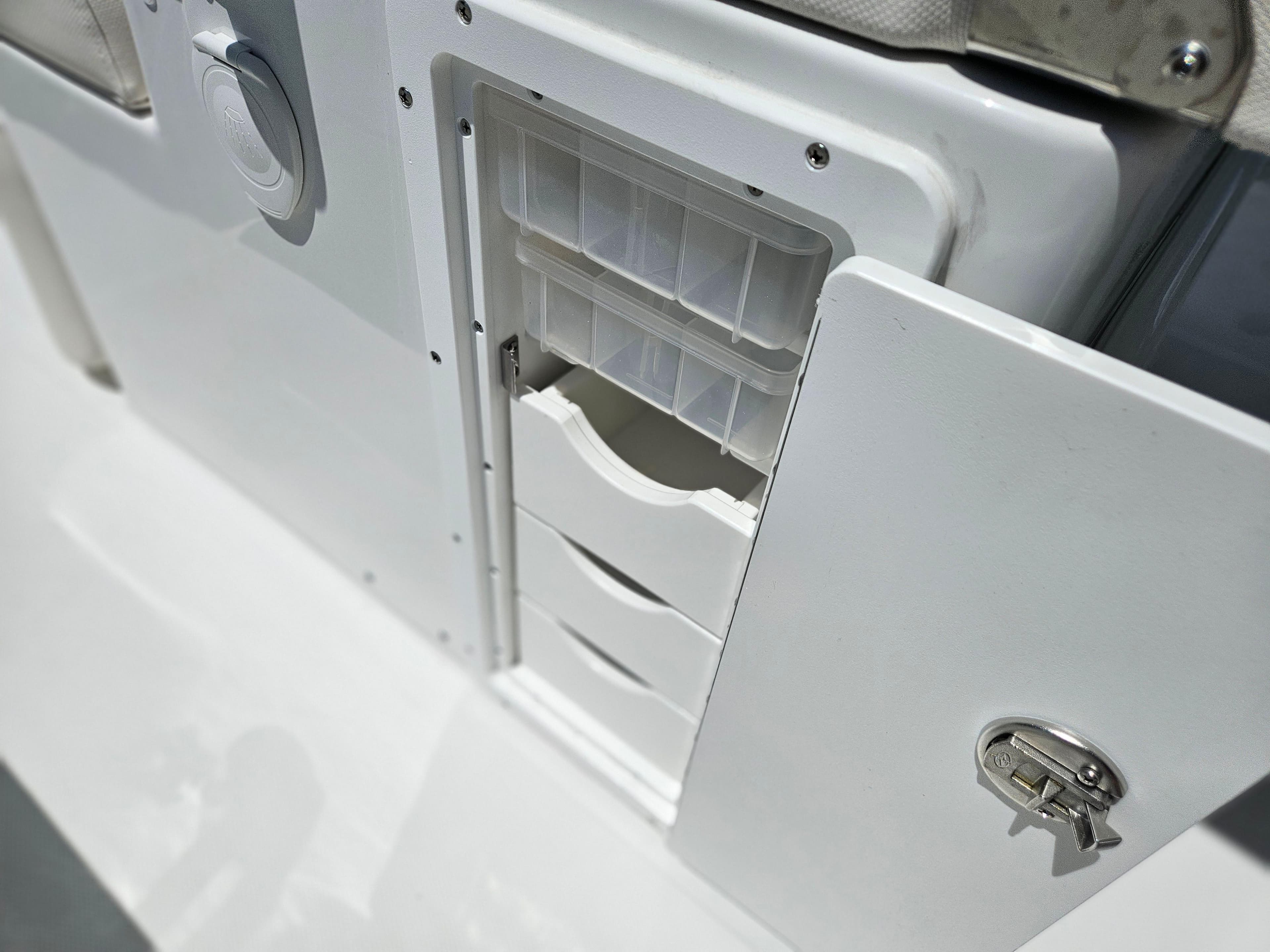 Storage compartment on 2026 Sea Hunt Ultra 275 SE boat, featuring secure lock and organized drawers.