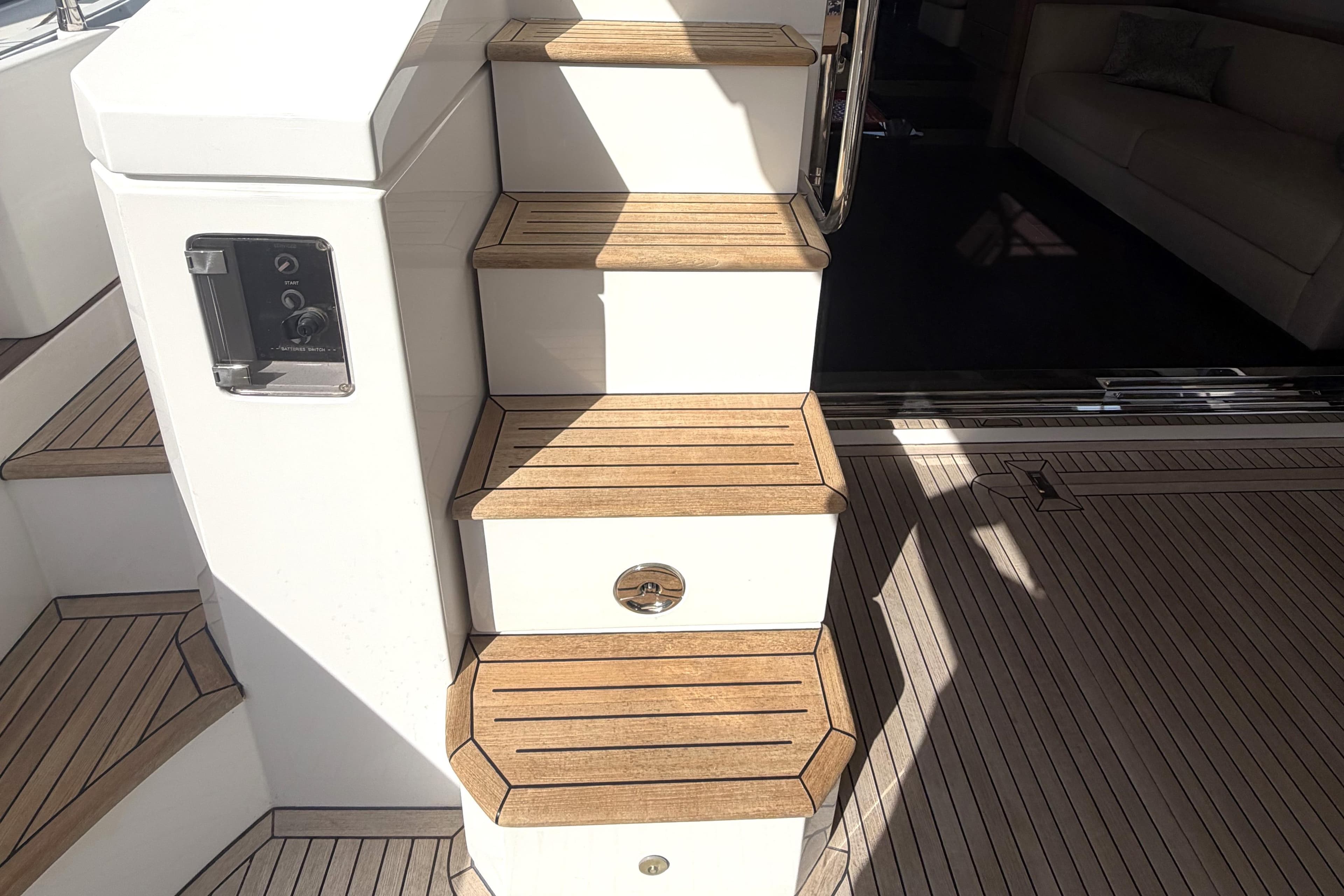 Staircase on 2021 Azimut 66 yacht with teak wood finish and modern design.
