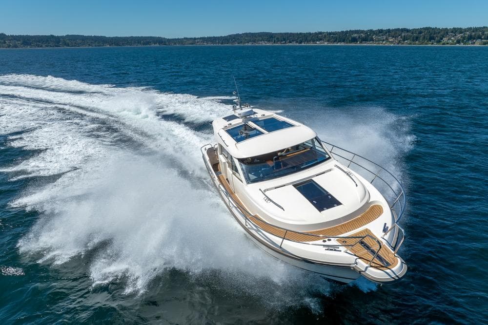 2022 Nimbus 405 Coupé yacht cruising on open water, creating a dynamic wake.