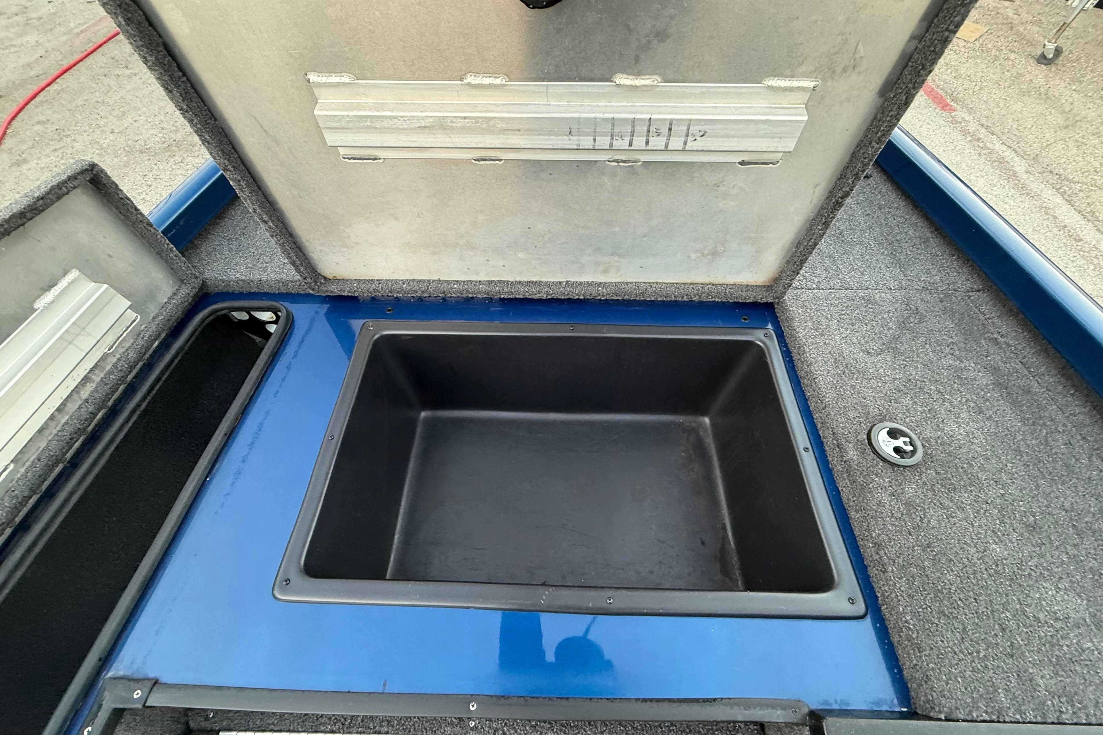 Open storage compartment in 2020 Triton 17 TX boat, featuring blue and gray interior.