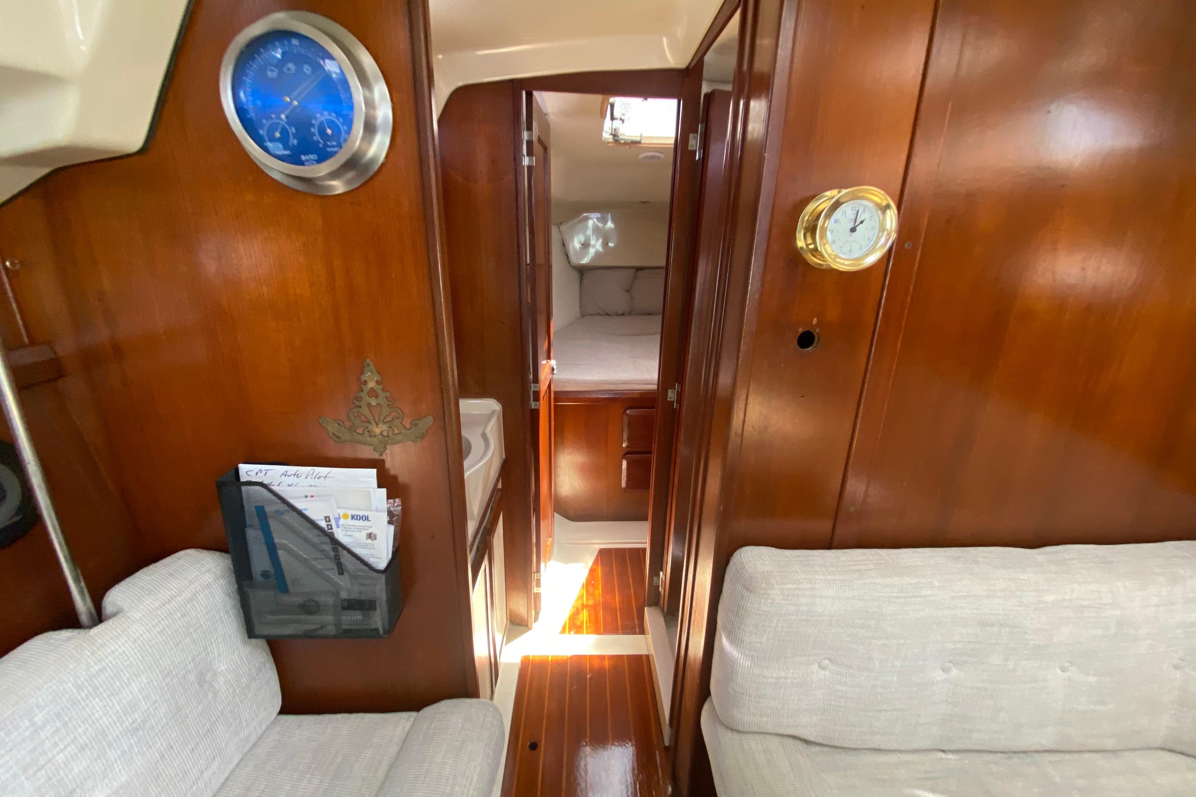 Interior of a 1995 Hunter 33.5 sailboat with wood paneling and cozy seating.