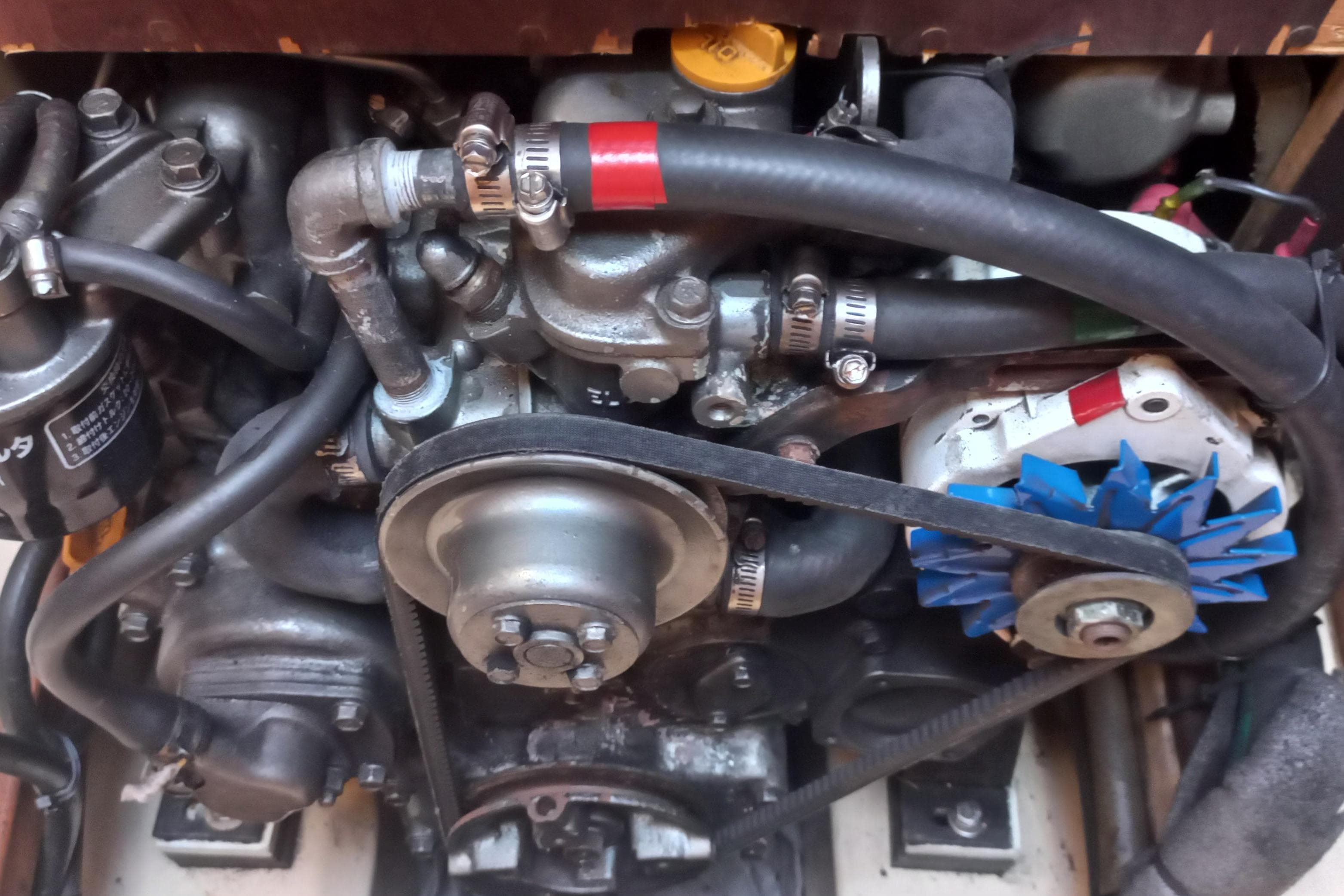 Engine components of a 1999 Island Packet 350 sailboat, featuring hoses and belts.