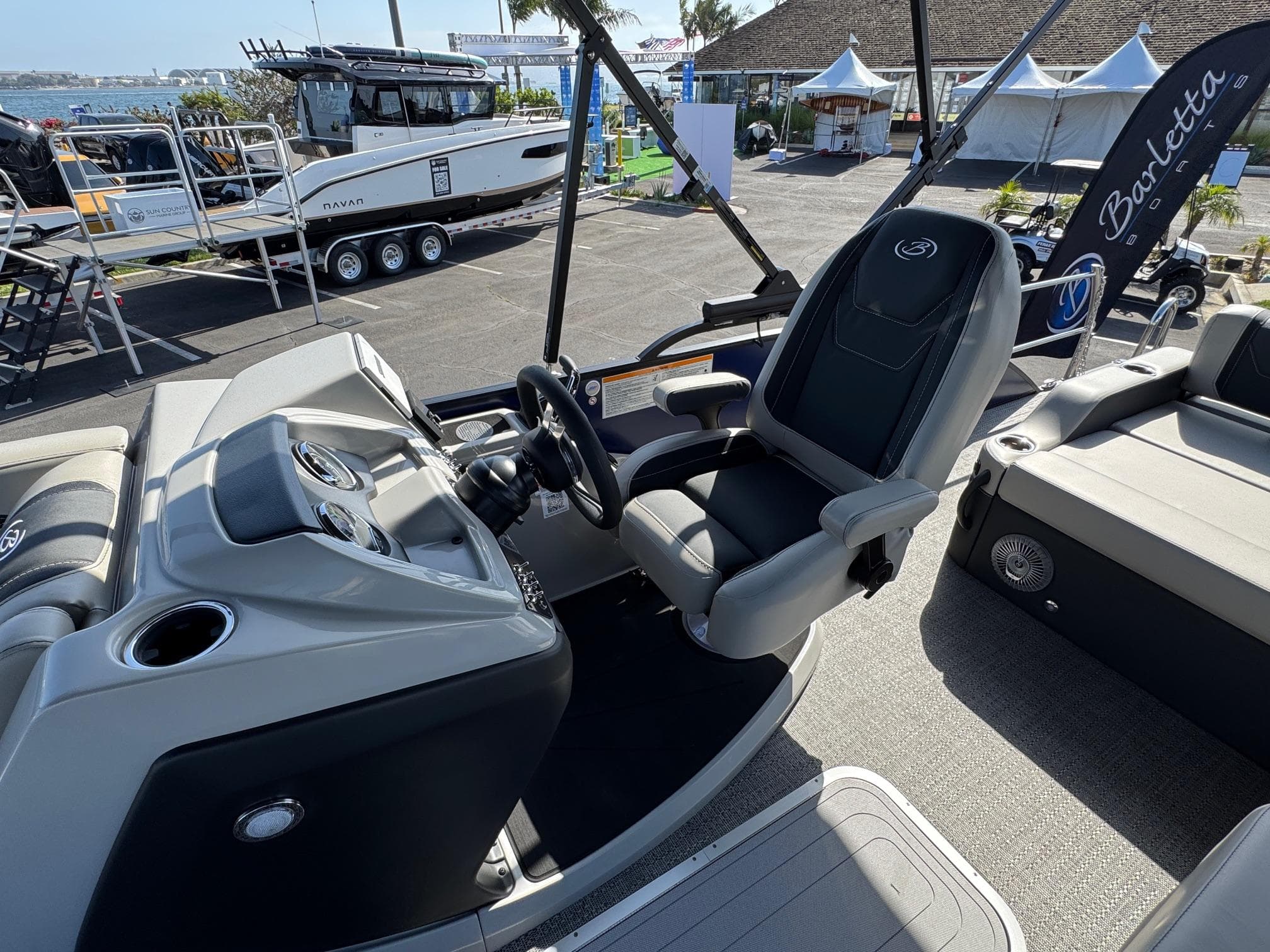 2026 Barletta Cabrio 24U boat interior with steering wheel and seating.