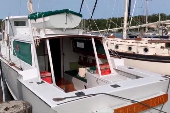 1963 Wiley Trawler docked at marina, featuring green accents and classic design.