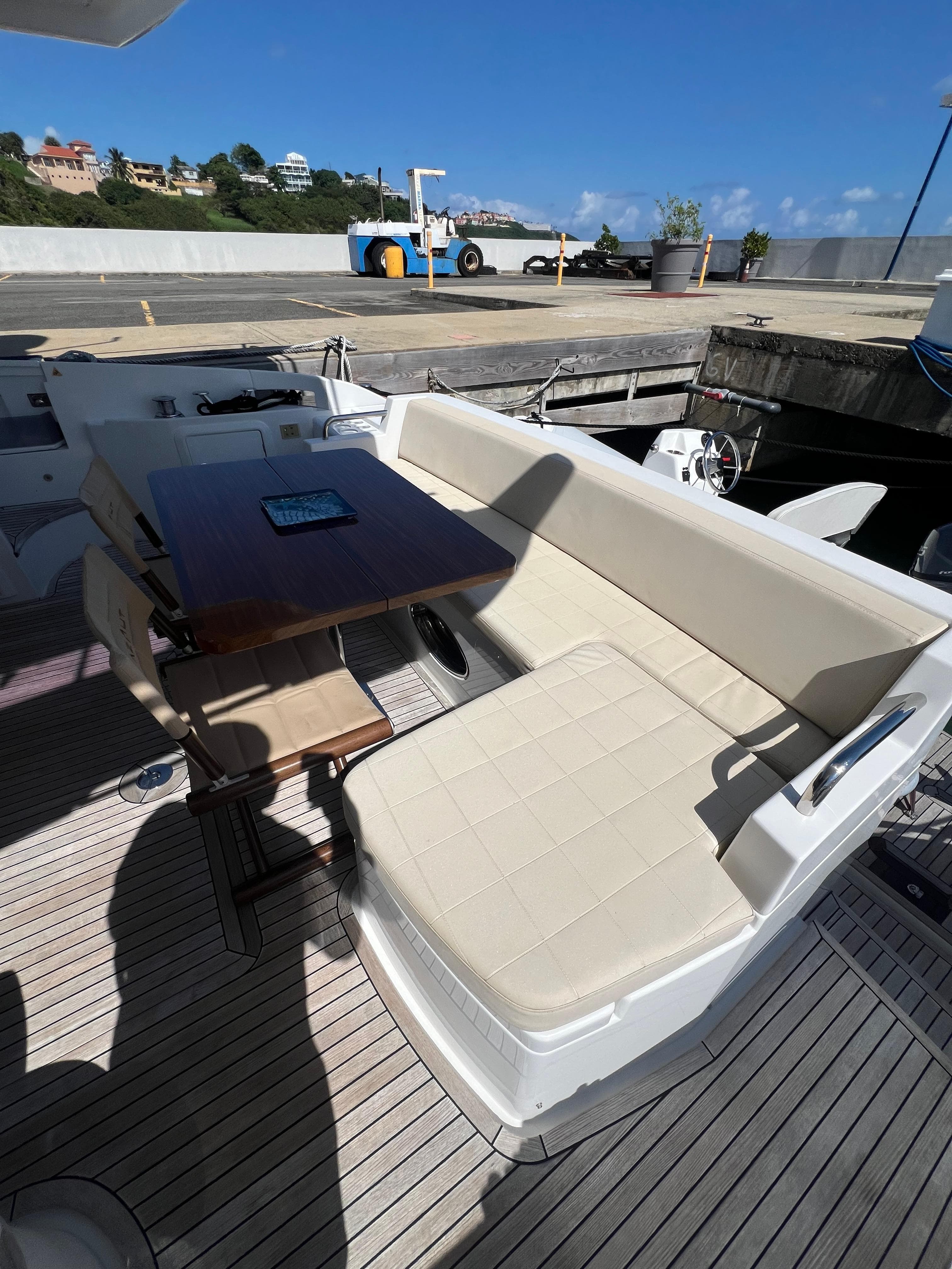 Azimut 54fly 2016 yacht with outdoor seating and table, docked under clear blue sky.