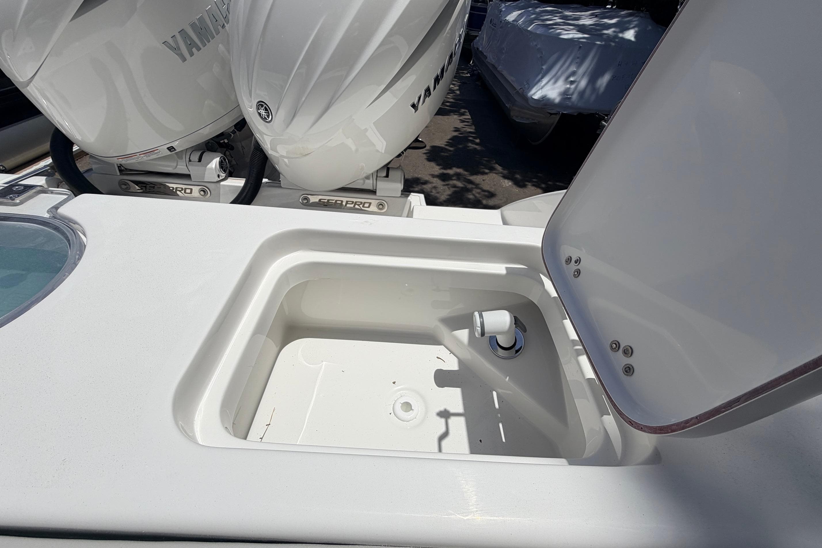 Open storage compartment on 2026 Sea Pro 262 Offshore boat with Yamaha engines.
