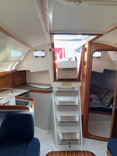 Interior of a 2002 C&C 99 sailboat, featuring a compact cabin with wooden accents.