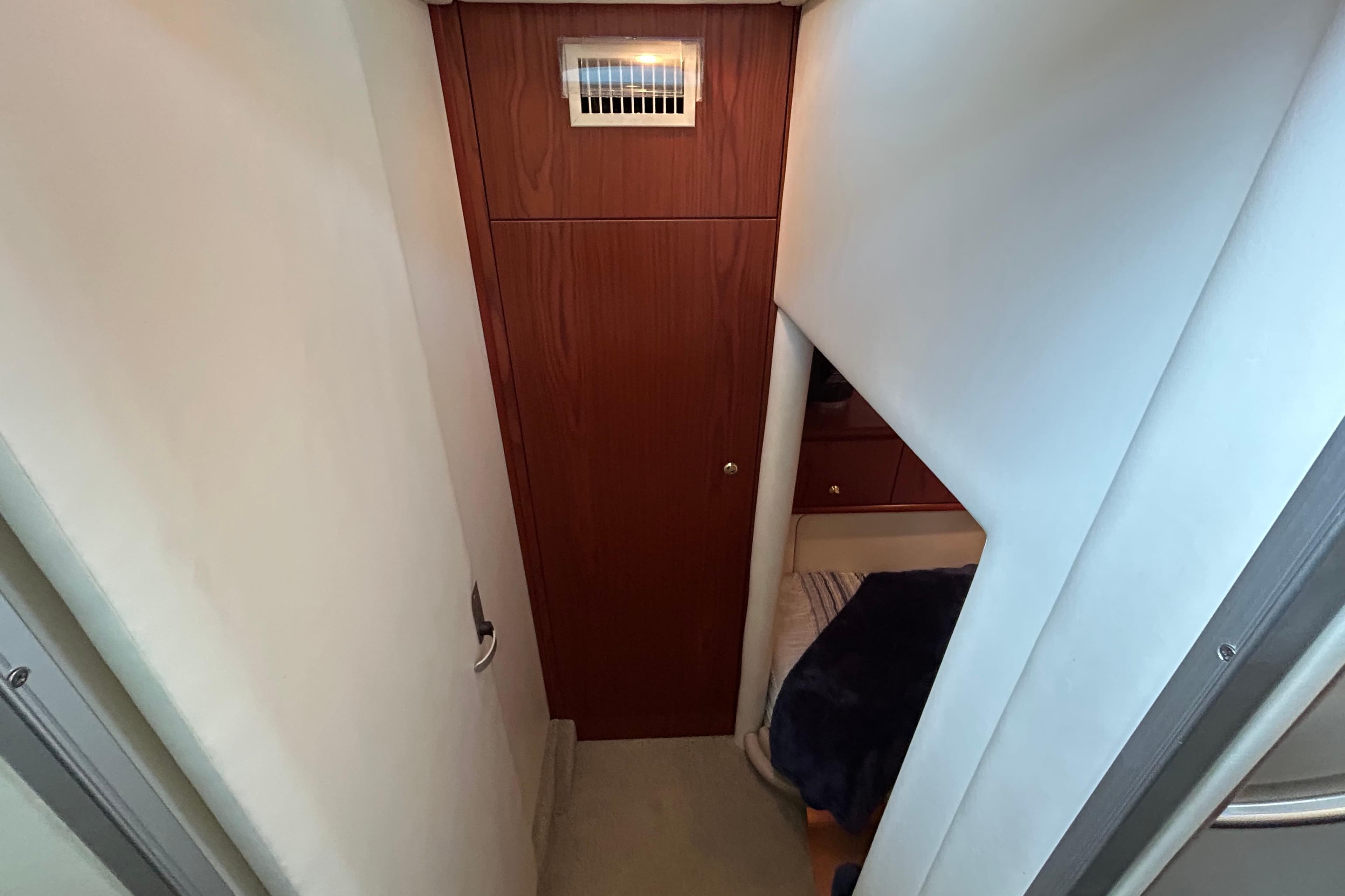 1999 Maxum 4600 SCB yacht interior hallway with wooden door and cozy cabin view.