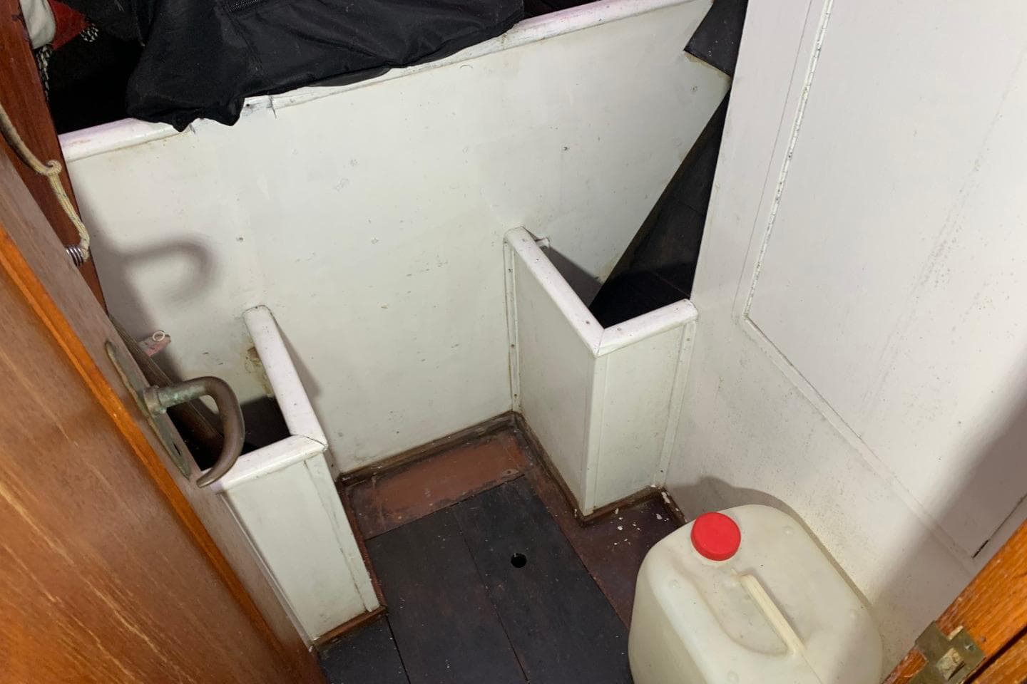 1979 Bueltjer Motorsailer interior with storage compartments and a plastic container.