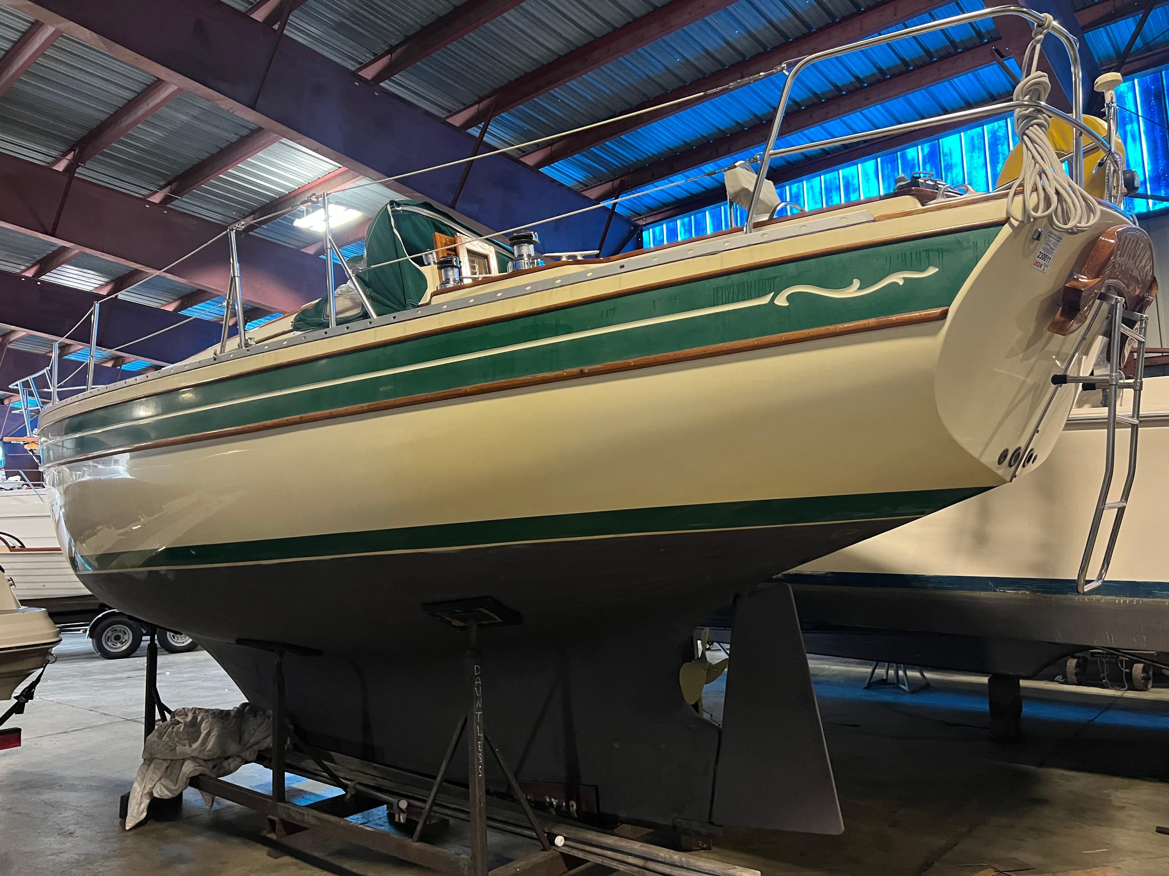 1987 Bayfield 32C sailboat in a warehouse, green and white hull, on a stand.