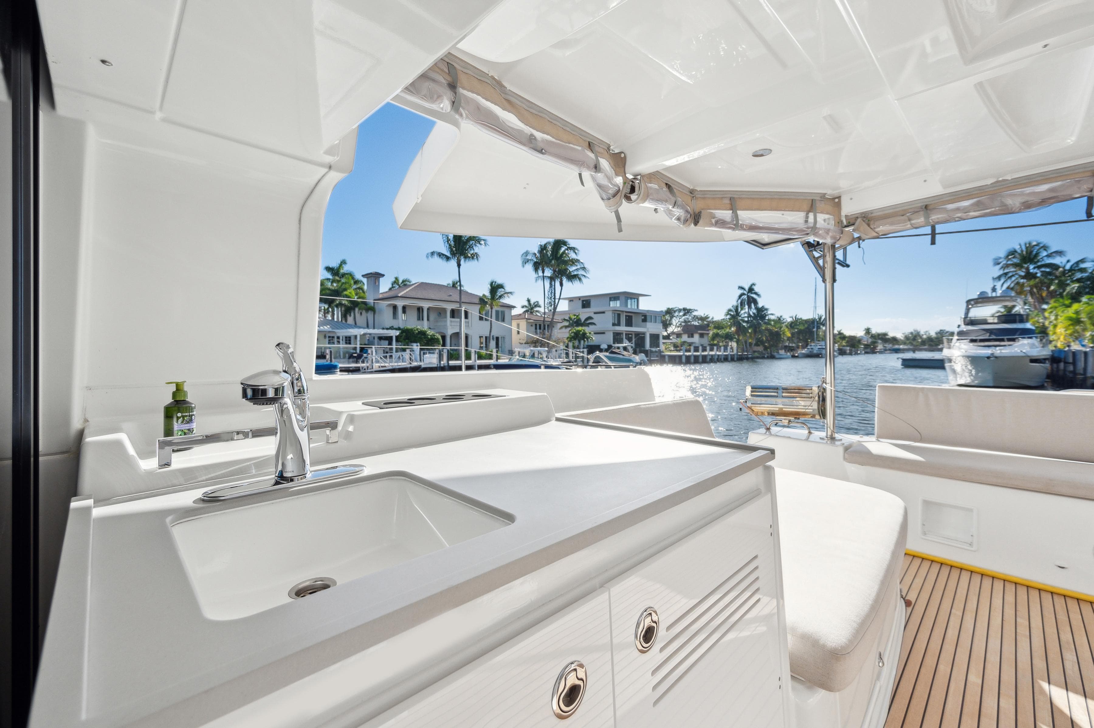 2022 Lagoon 46 yacht interior with sink, seating, and waterfront view.