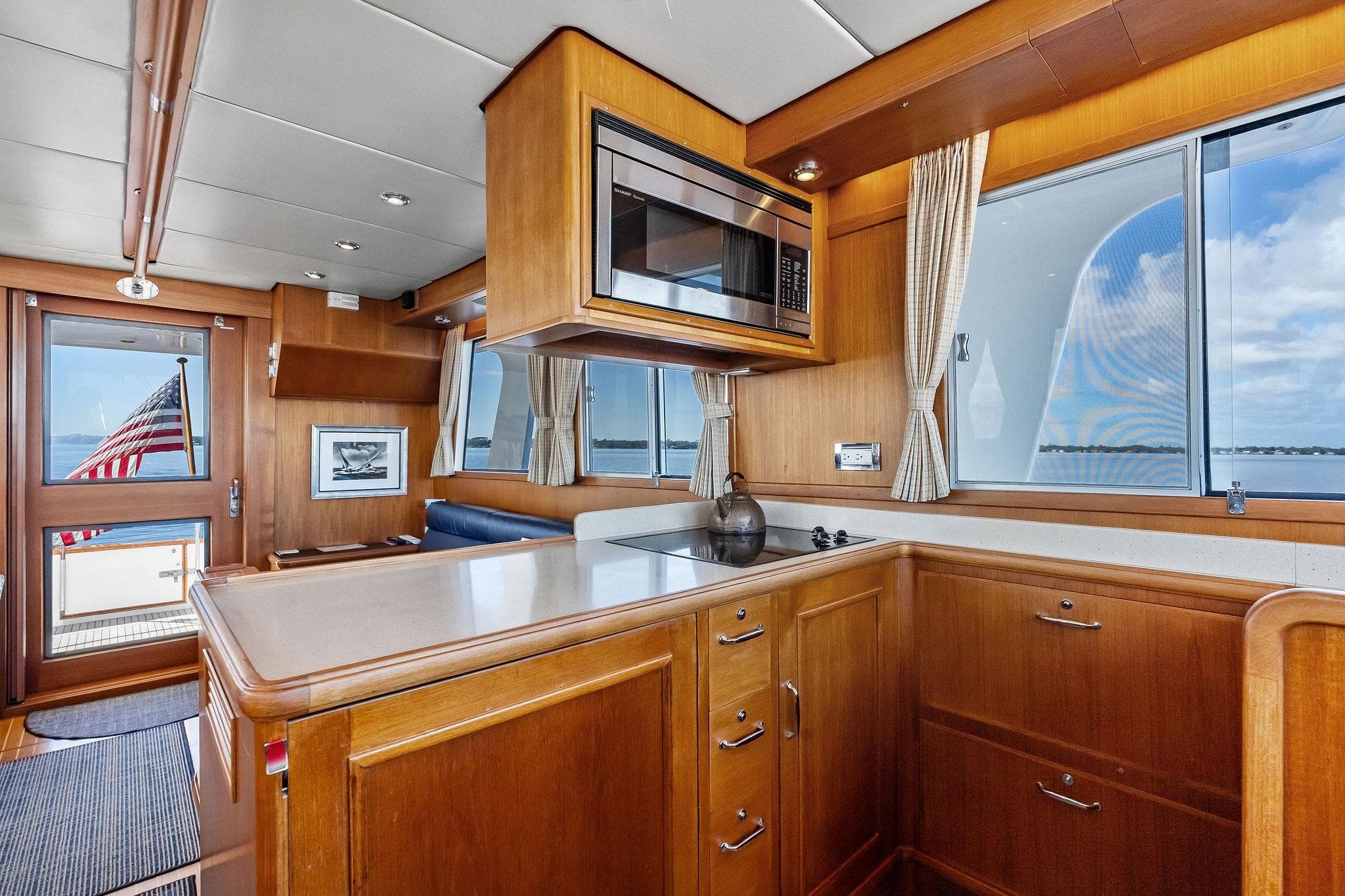 Interior of 2006 Grand Banks Europa 47 yacht with wooden cabinetry and ocean view.