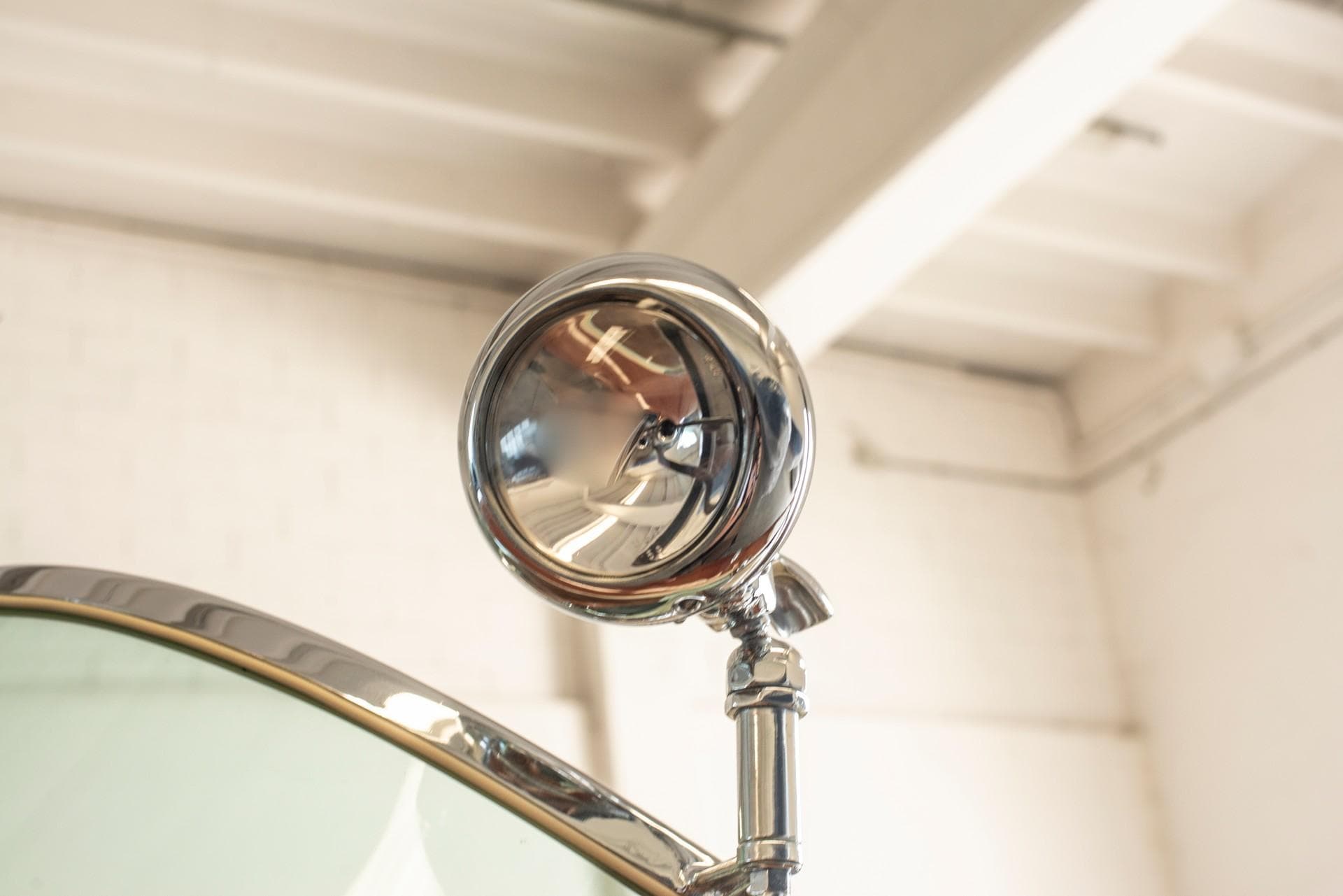 Close-up of a 1969 Riva Olympic boat's chrome spotlight and windshield.