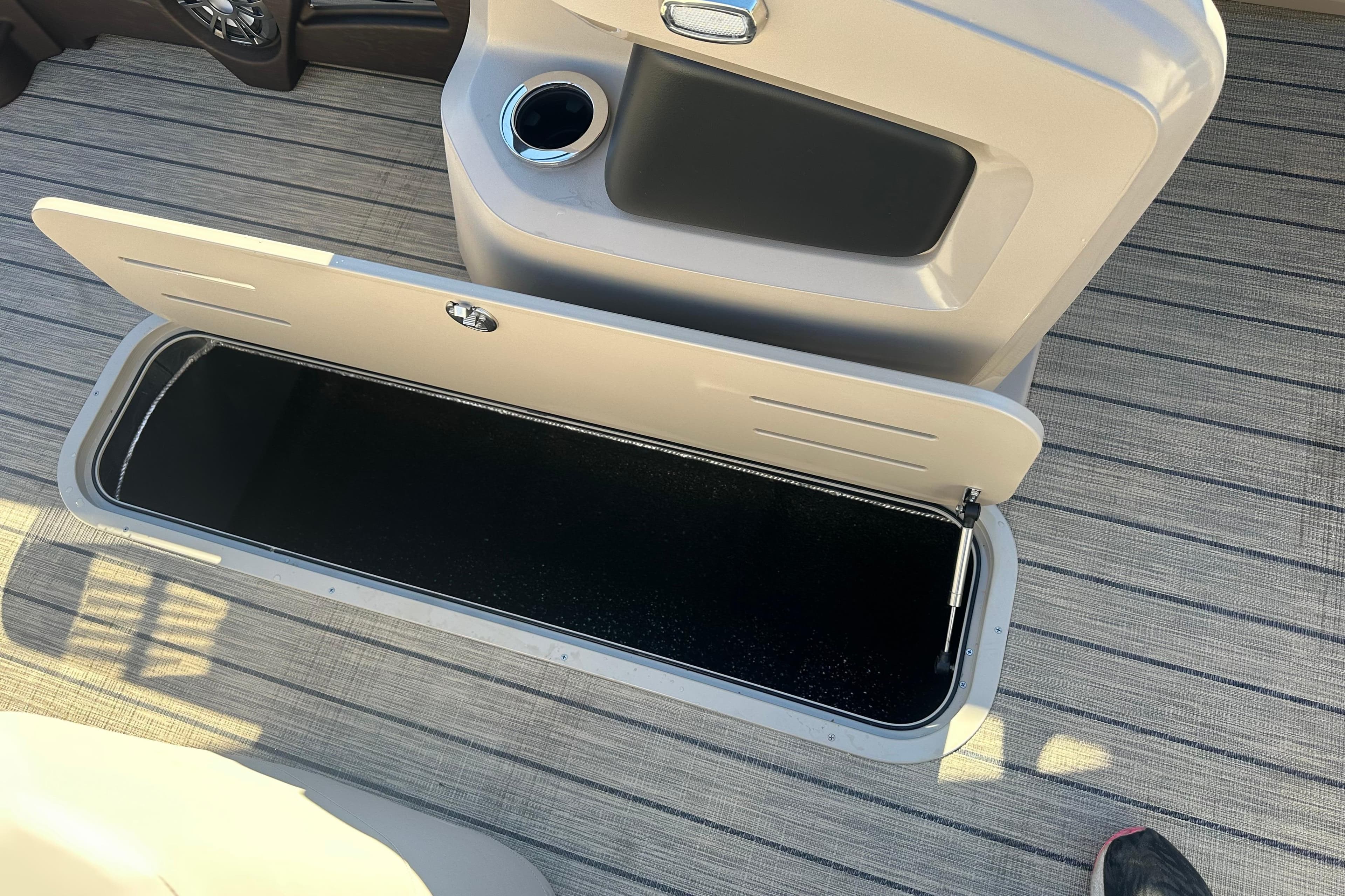 Open storage compartment on 2026 Tahoe Pontoon LTZ Cruise Rear Bench boat.