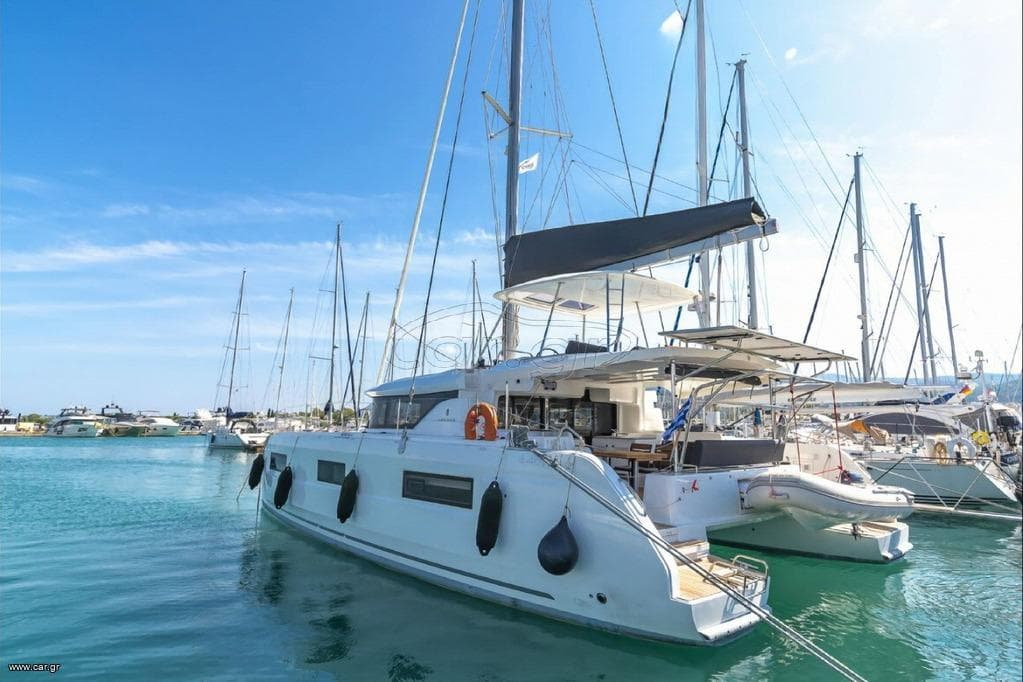 2021 Lagoon 46 catamaran docked in a marina under a clear blue sky.