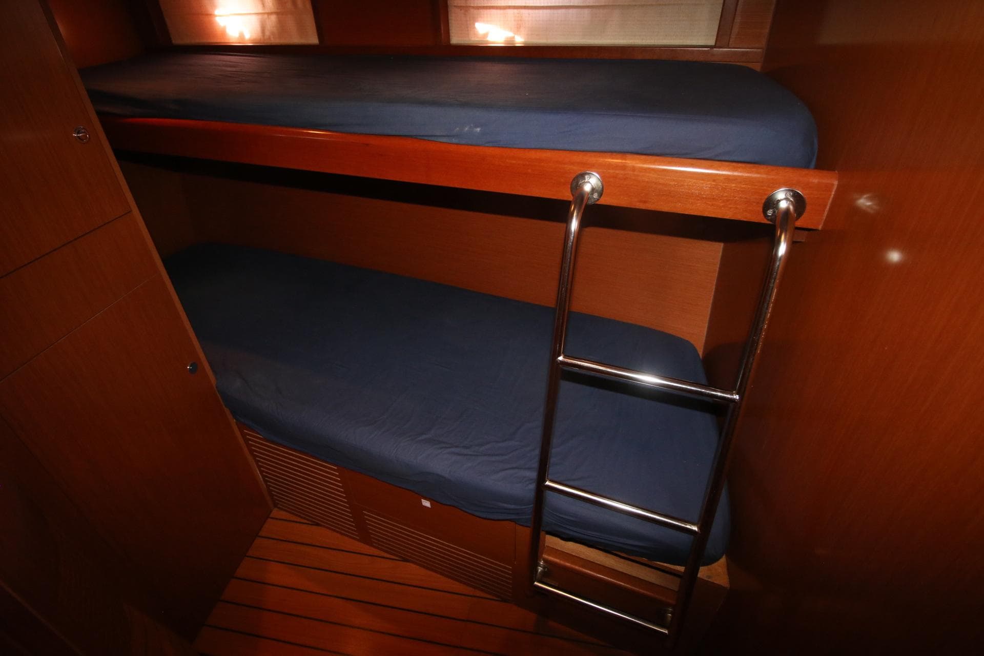 Bunk beds with blue bedding in 2008 Beneteau Swift Trawler 52 cabin interior.