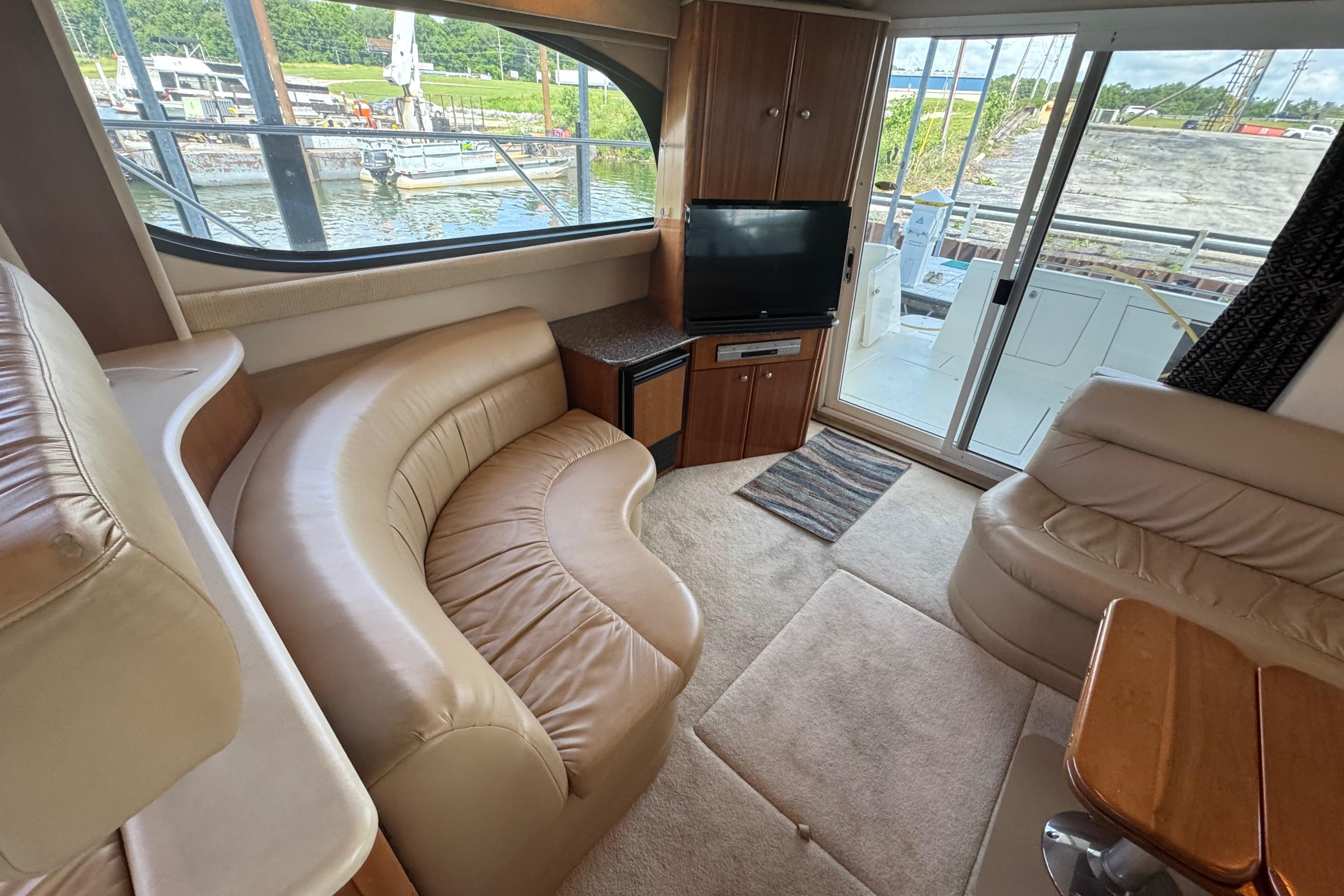 Luxurious interior of 2003 Meridian 411 Sedan yacht with leather seating and TV.