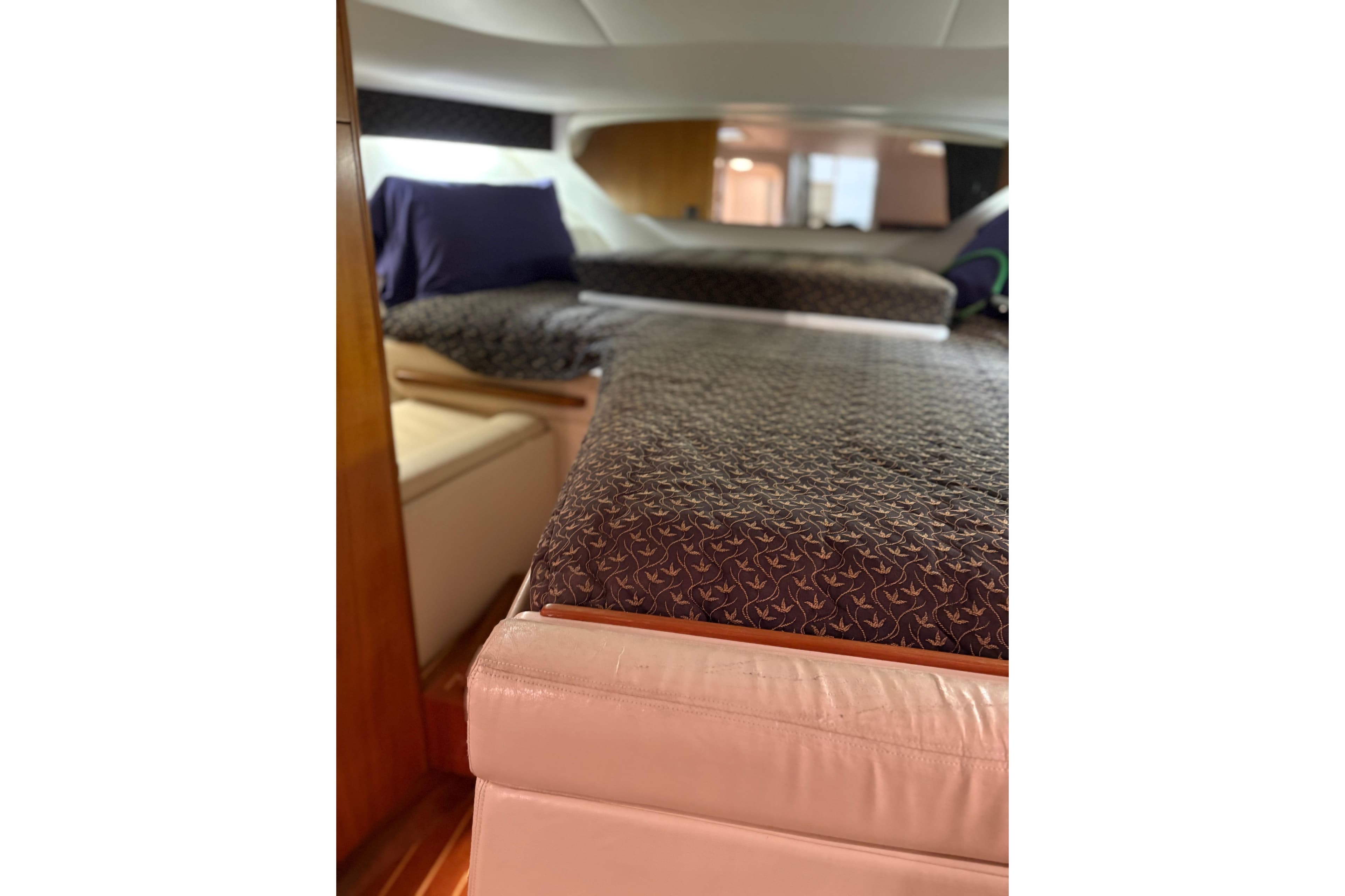 Interior cabin of 1994 Tiara Yachts 3100 Open, featuring patterned bedding and cozy seating.