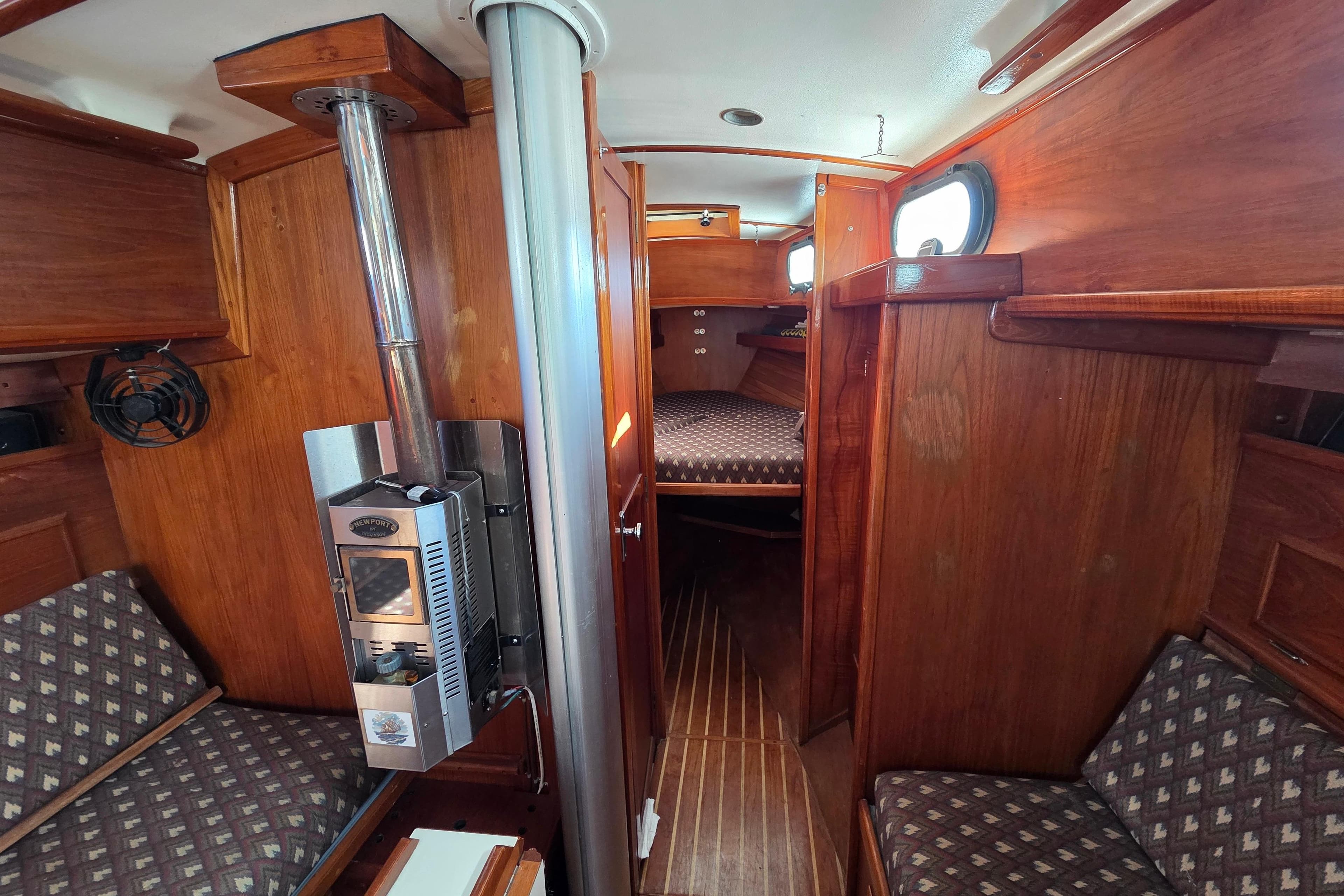 Interior of 1982 Cape Dory 33 sailboat with wood paneling and cozy seating.