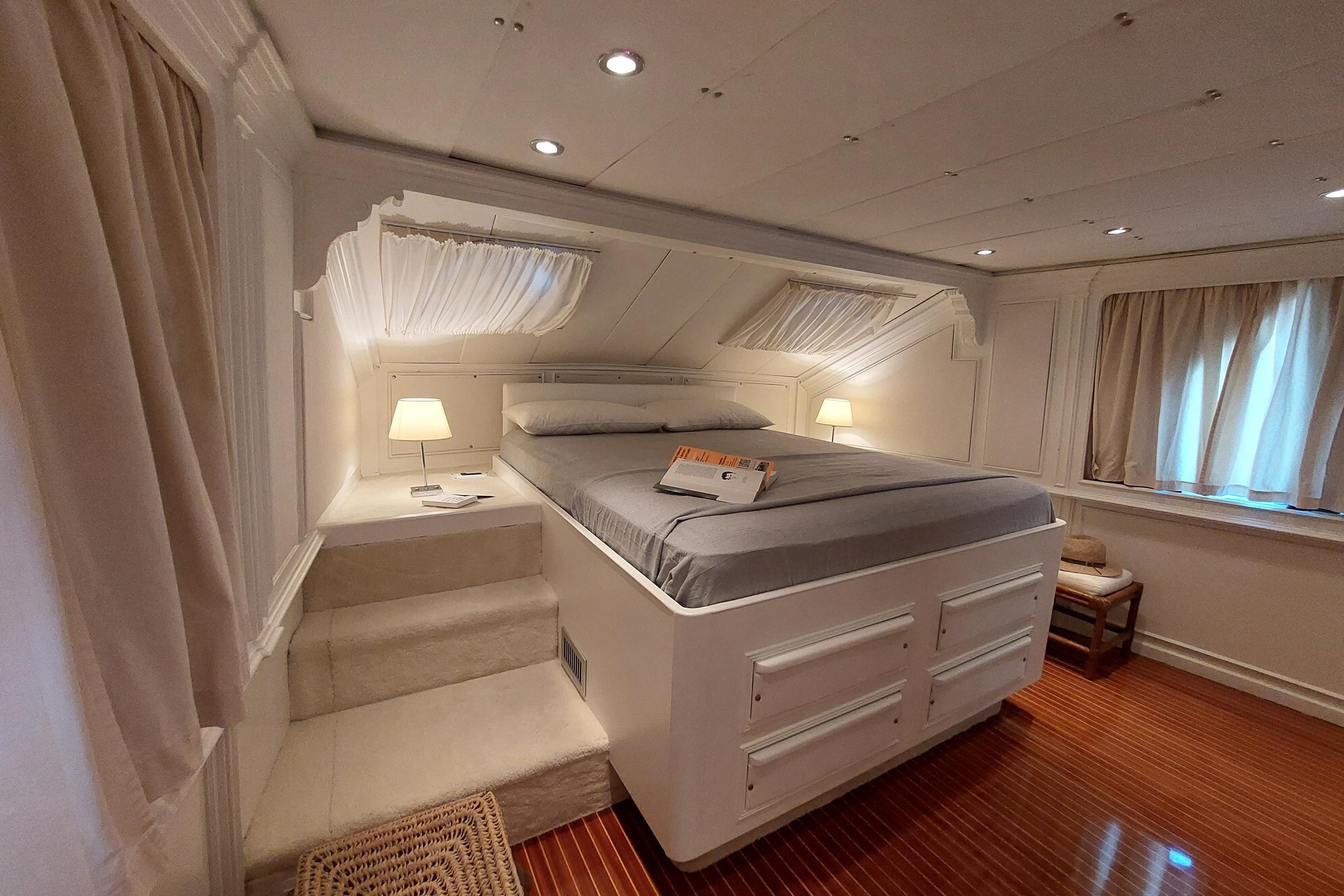 Luxurious bedroom interior on 1977 Codecasa 27m yacht, featuring elegant design and cozy lighting.