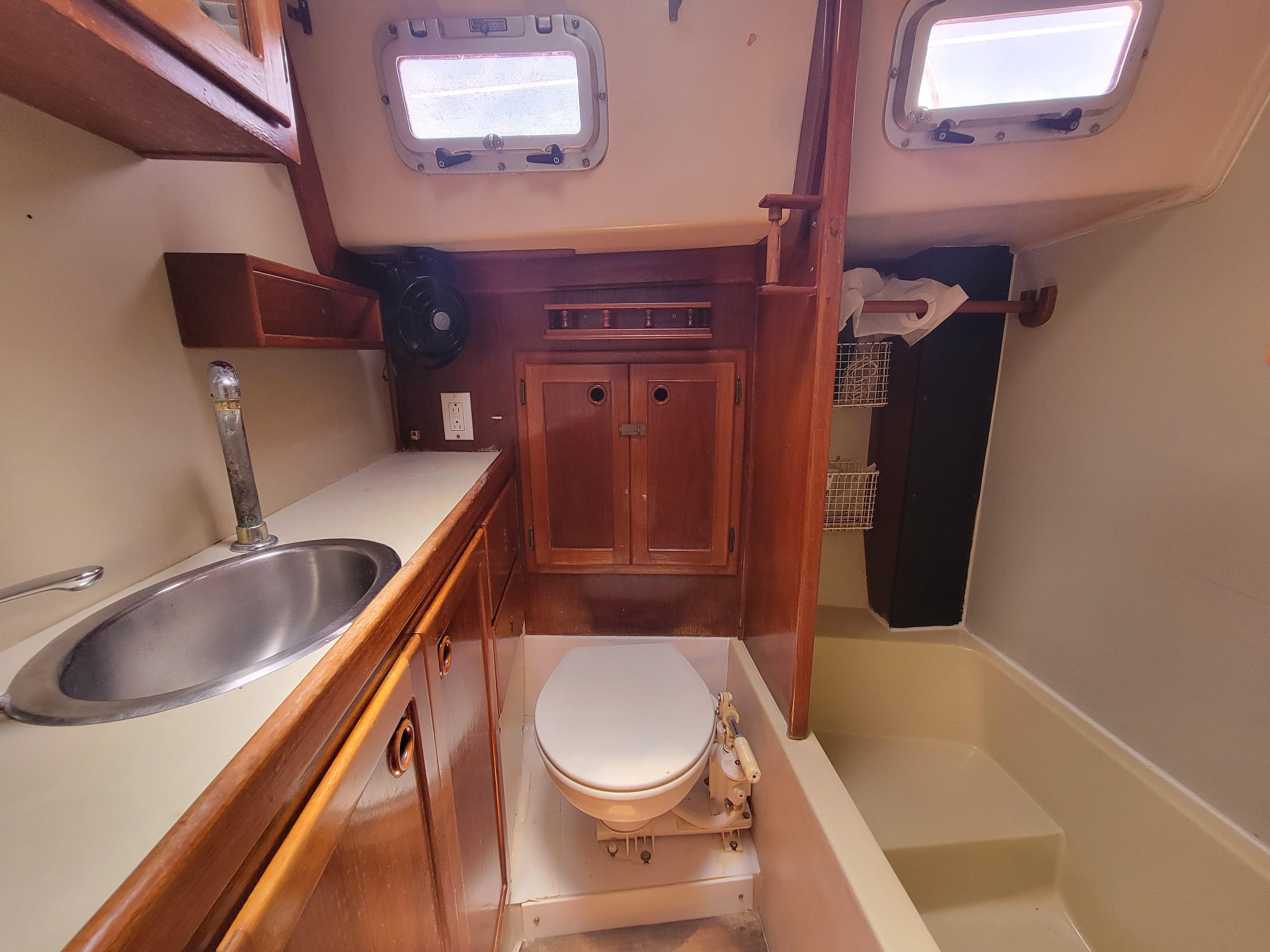 1987 Bayfield 36 yacht bathroom with sink, toilet, and storage cabinets.