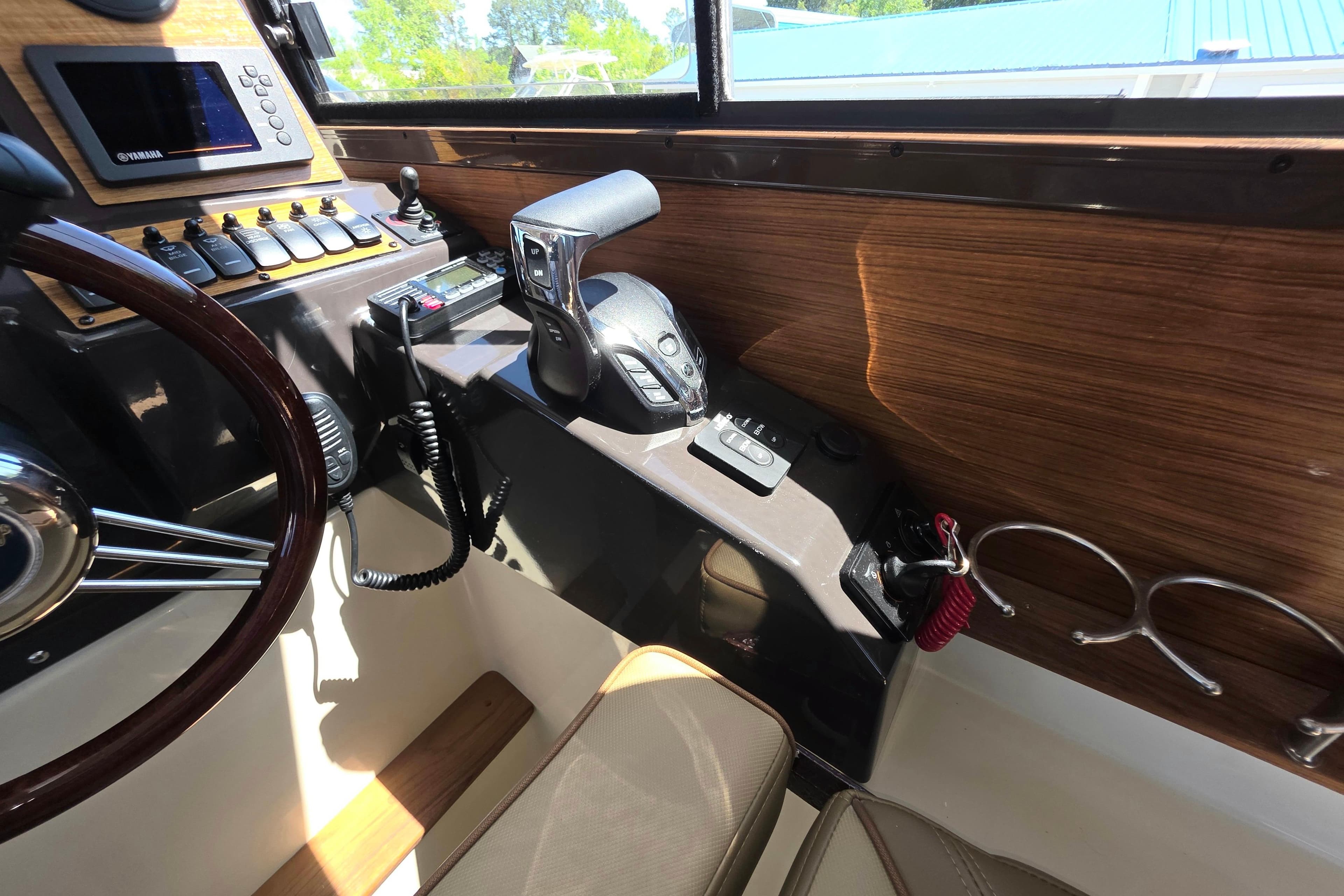 Interior helm of 2025 Ranger Tugs R-25 boat with modern controls and wood accents.