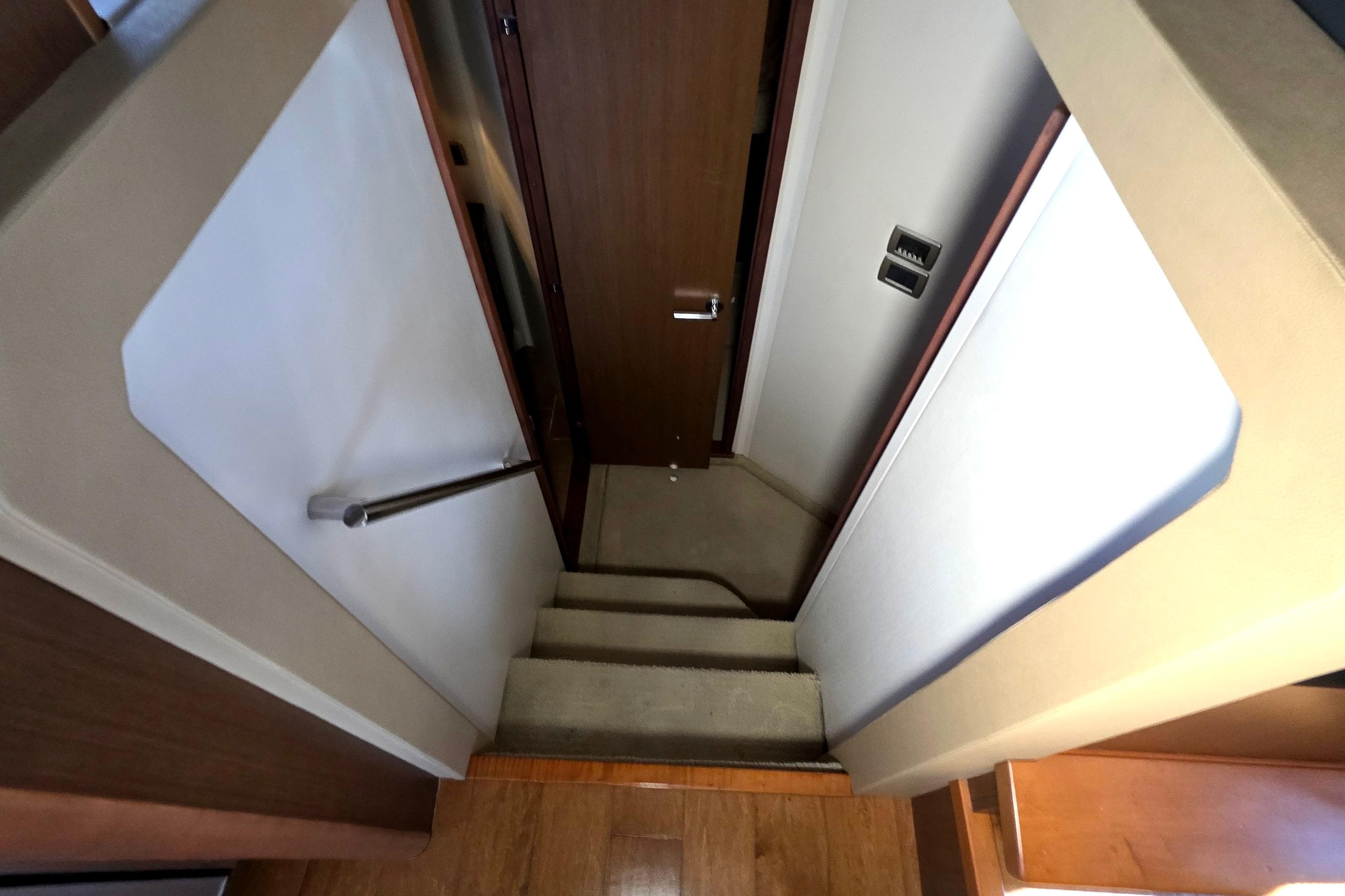 Staircase inside 2016 Sea Ray Sundancer 400 yacht, featuring wooden steps and modern design.