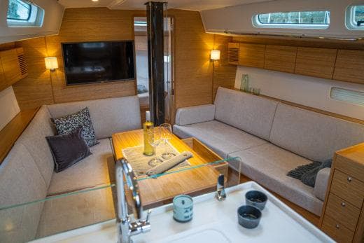 Luxurious interior of 2024 X-Yachts X4-0 sailboat with modern furnishings and cozy seating area.