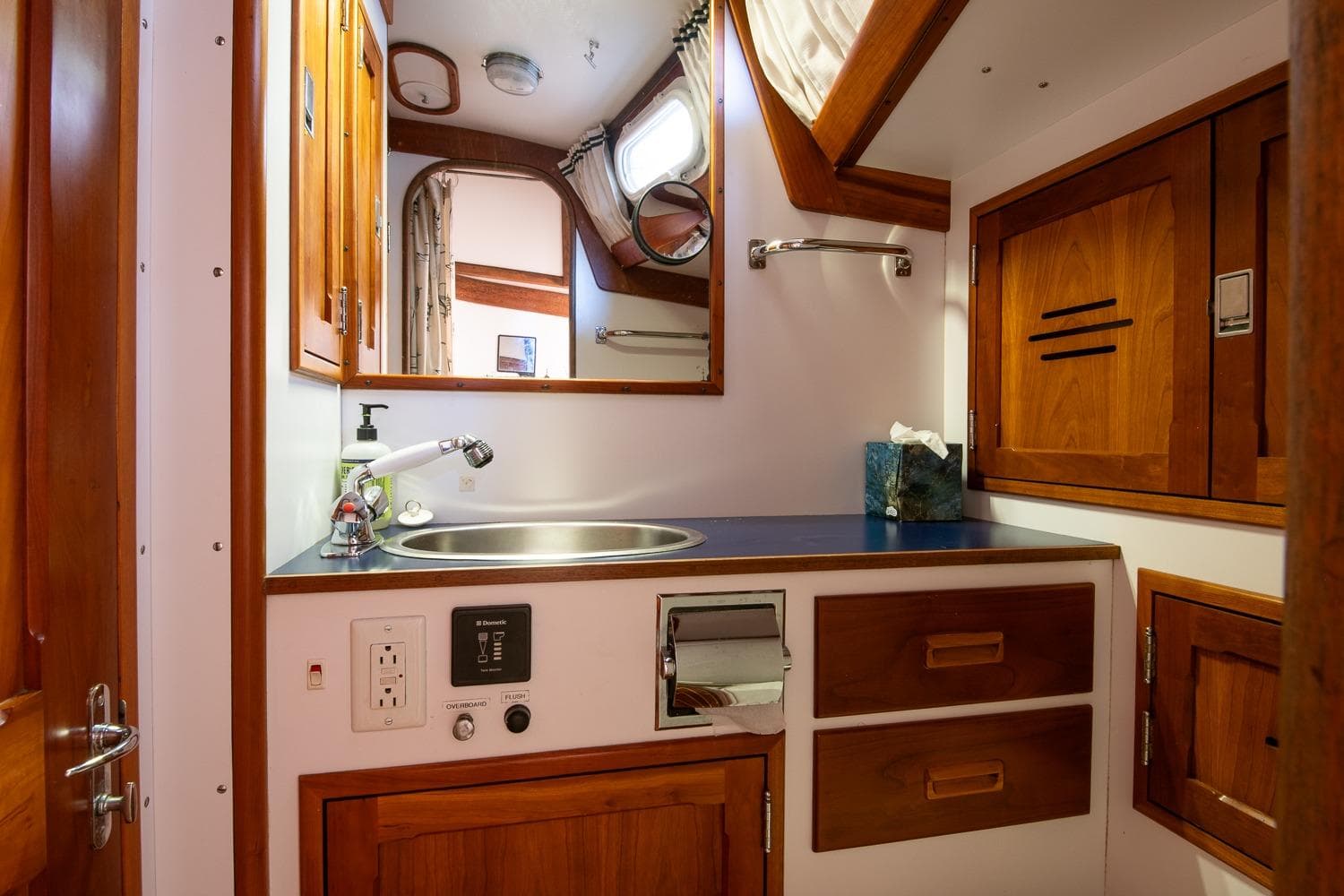 Hinckley Sou'wester 51 yacht bathroom, featuring wooden cabinetry and a sleek sink, 1989 model.