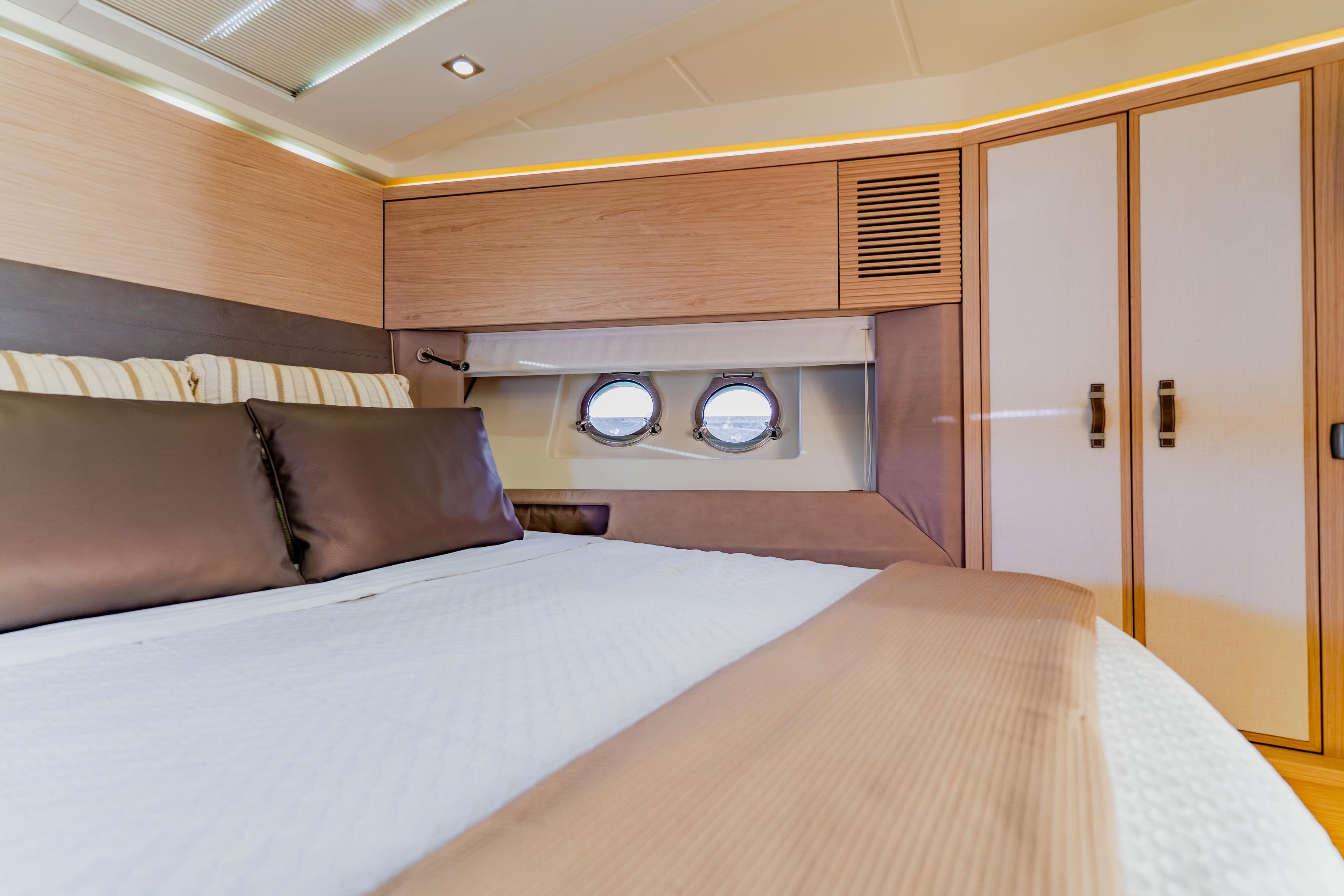 Luxurious interior cabin of 2015 Monte Carlo MC5 yacht with elegant bedding and porthole.