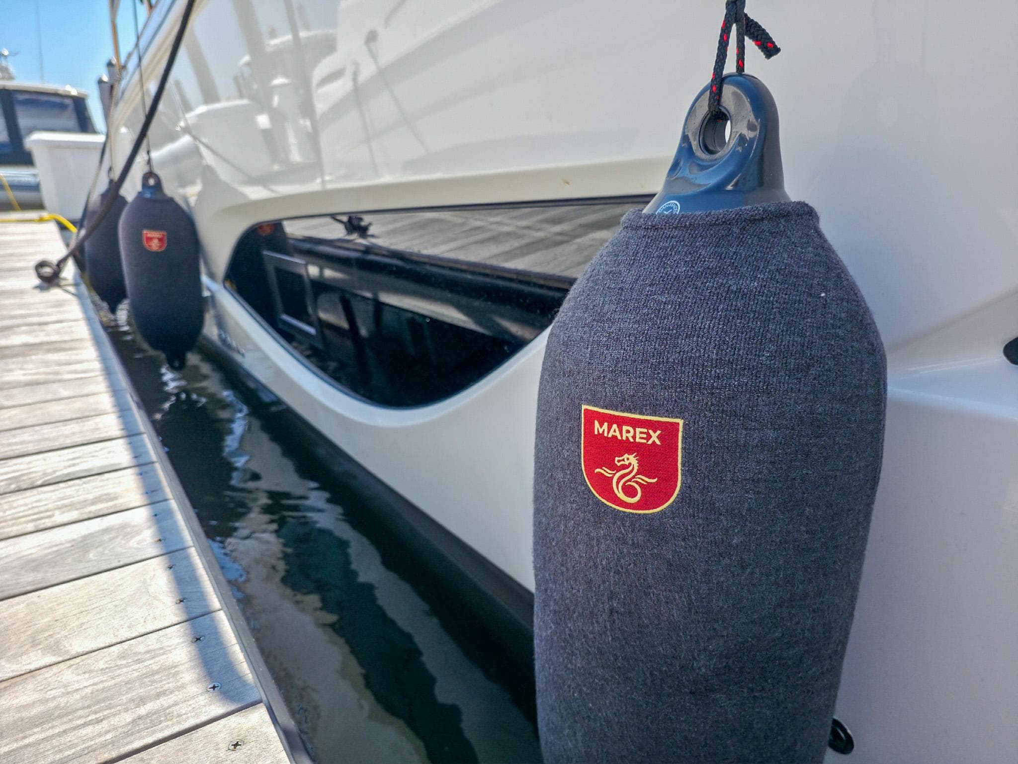 2026 Marex 440 yacht docked with protective fenders, showcasing brand logo.