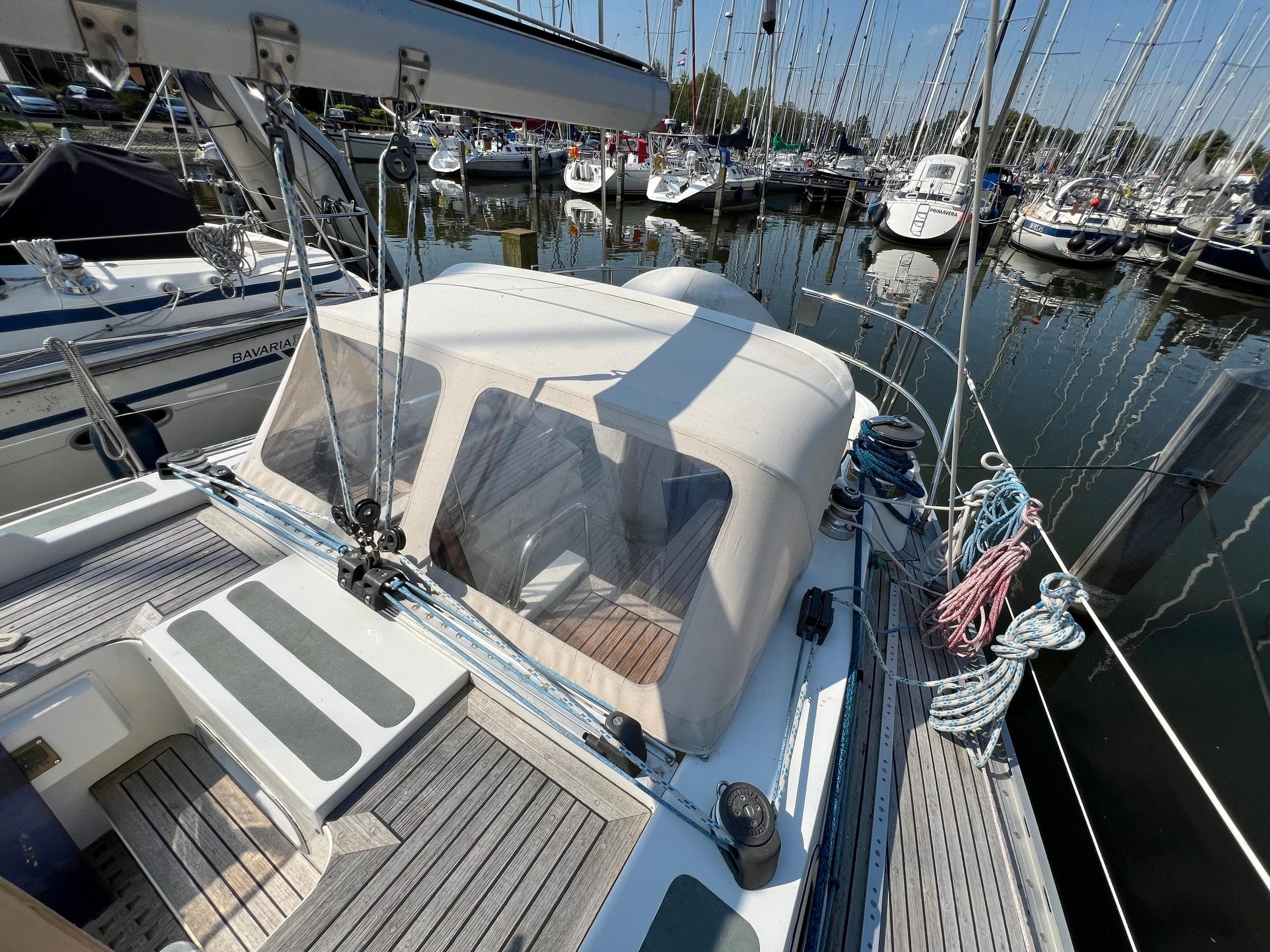 1986 Jonmeri 40 sailboat docked in a marina, featuring a covered cockpit and wooden deck.