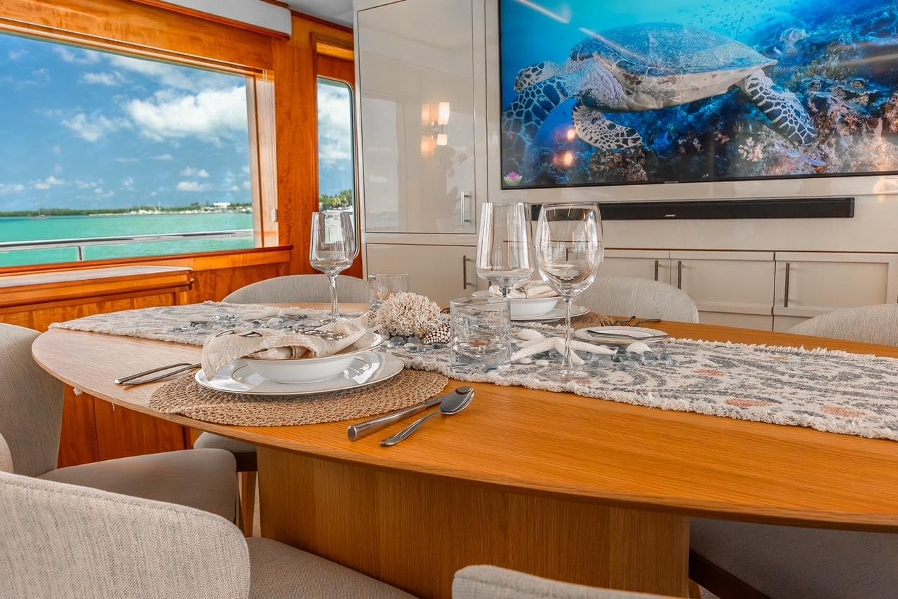 Luxurious dining area on 2001 Intermarine RPH 95 yacht with ocean view and elegant table setting.