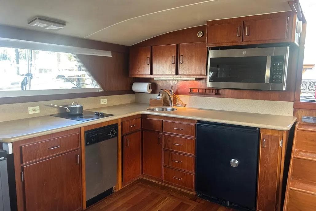 1978 Chris-Craft 45 Commander yacht kitchen with wooden cabinets and modern appliances.