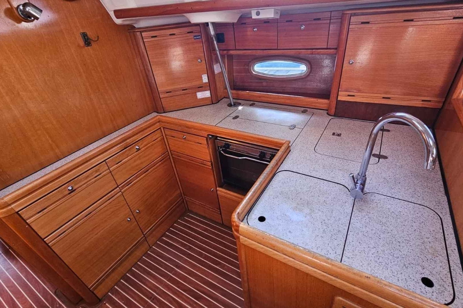Luxurious 2006 Bavaria Cruiser 50 yacht kitchen with wooden cabinetry and modern fixtures.