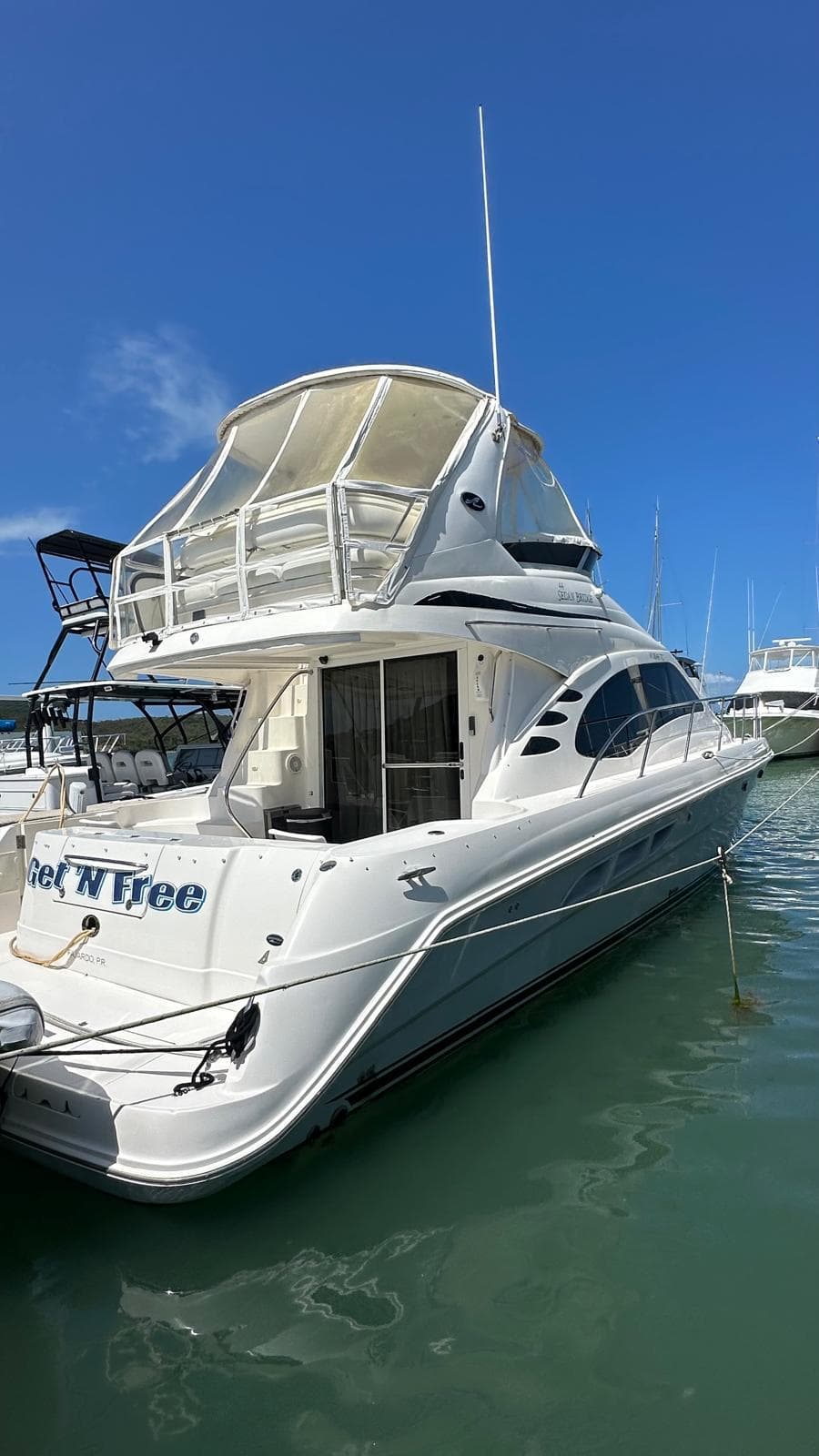 2006 Sea Ray 44 Sedan Bridge yacht docked in marina under clear blue sky.