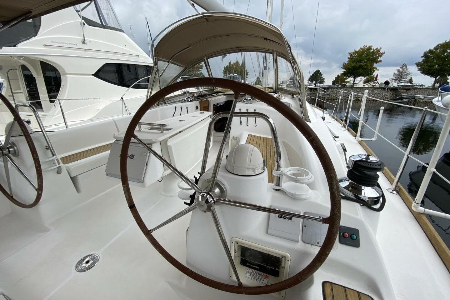 2009 Beneteau 43 sailboat cockpit with dual steering wheels and marina view.