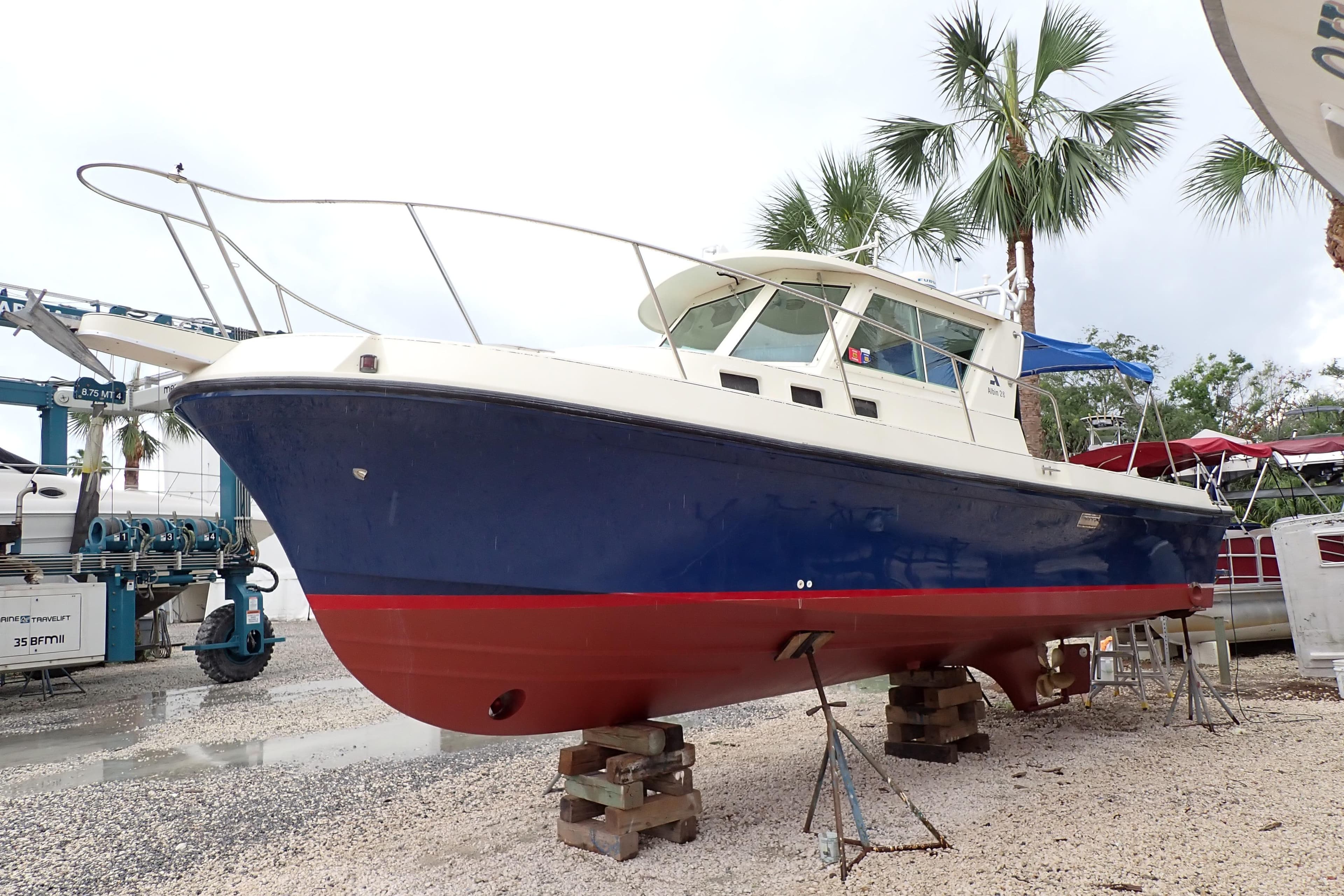 2000 Albin 28 Tournament Express boat on dry dock with palm trees in background.