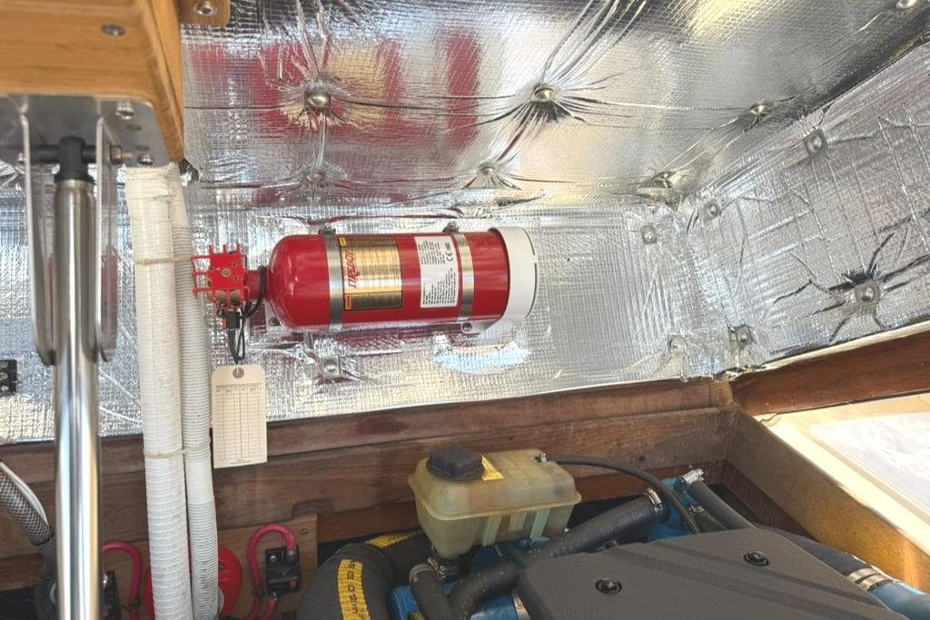 Engine compartment of 1986 Dusky 26 Custom with fire extinguisher and insulation.