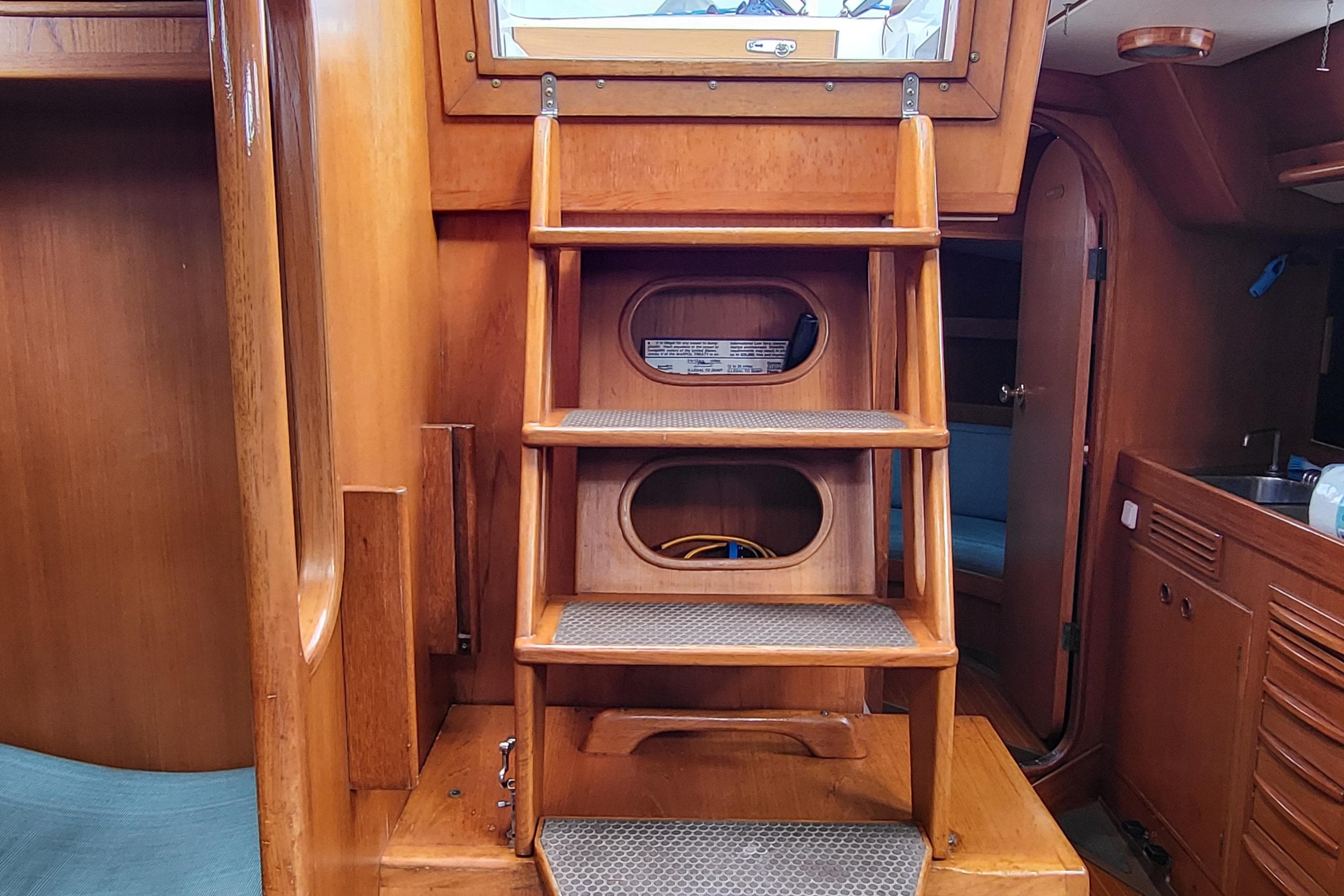 Interior of 1985 Swan 46 yacht with wooden stairs and cabin view.