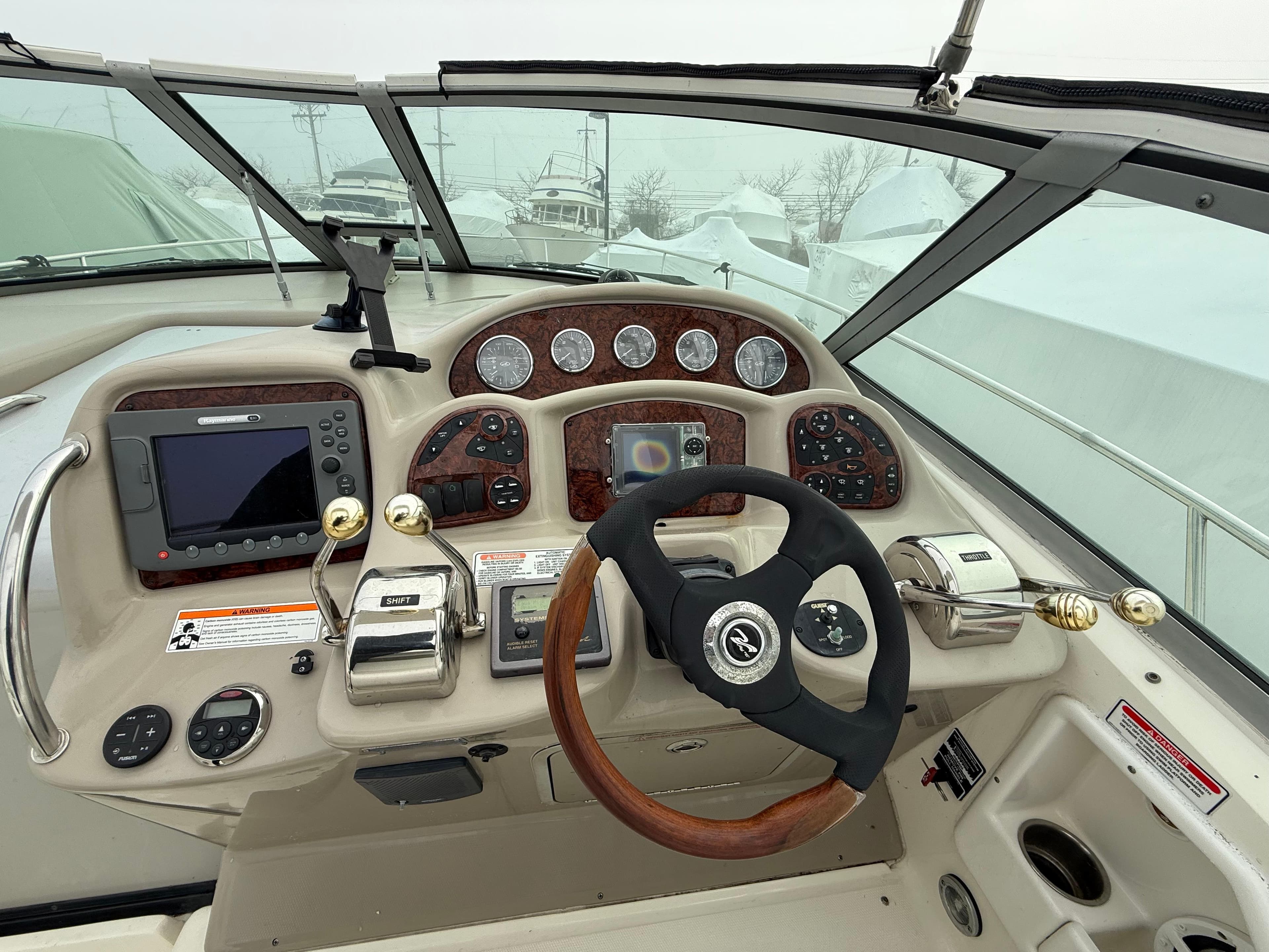 Helm of 2006 Sea Ray 320 Sundancer with gauges, steering wheel, and navigation equipment.
