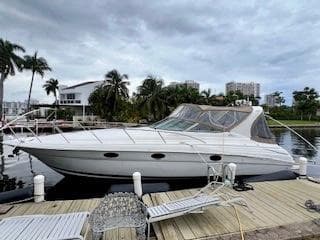2001 Wellcraft Martinique 3700 yacht docked by palm trees and waterfront homes.