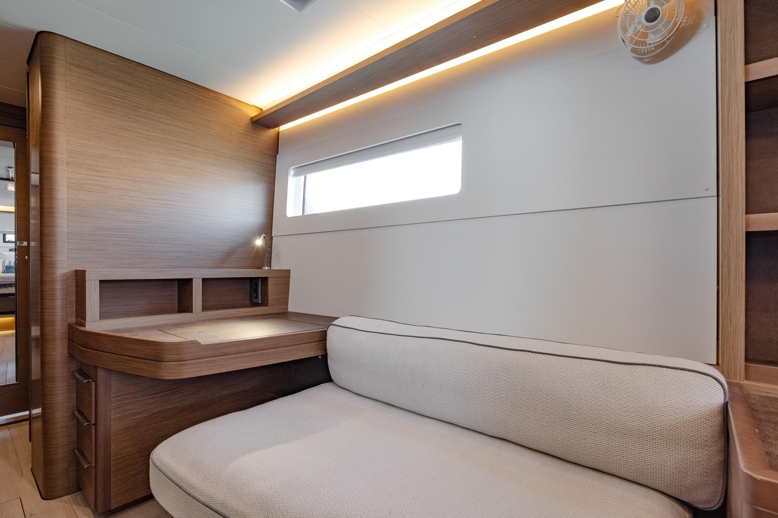 Modern interior of 2020 Lagoon 46 yacht with sleek wood finish and cozy seating area.