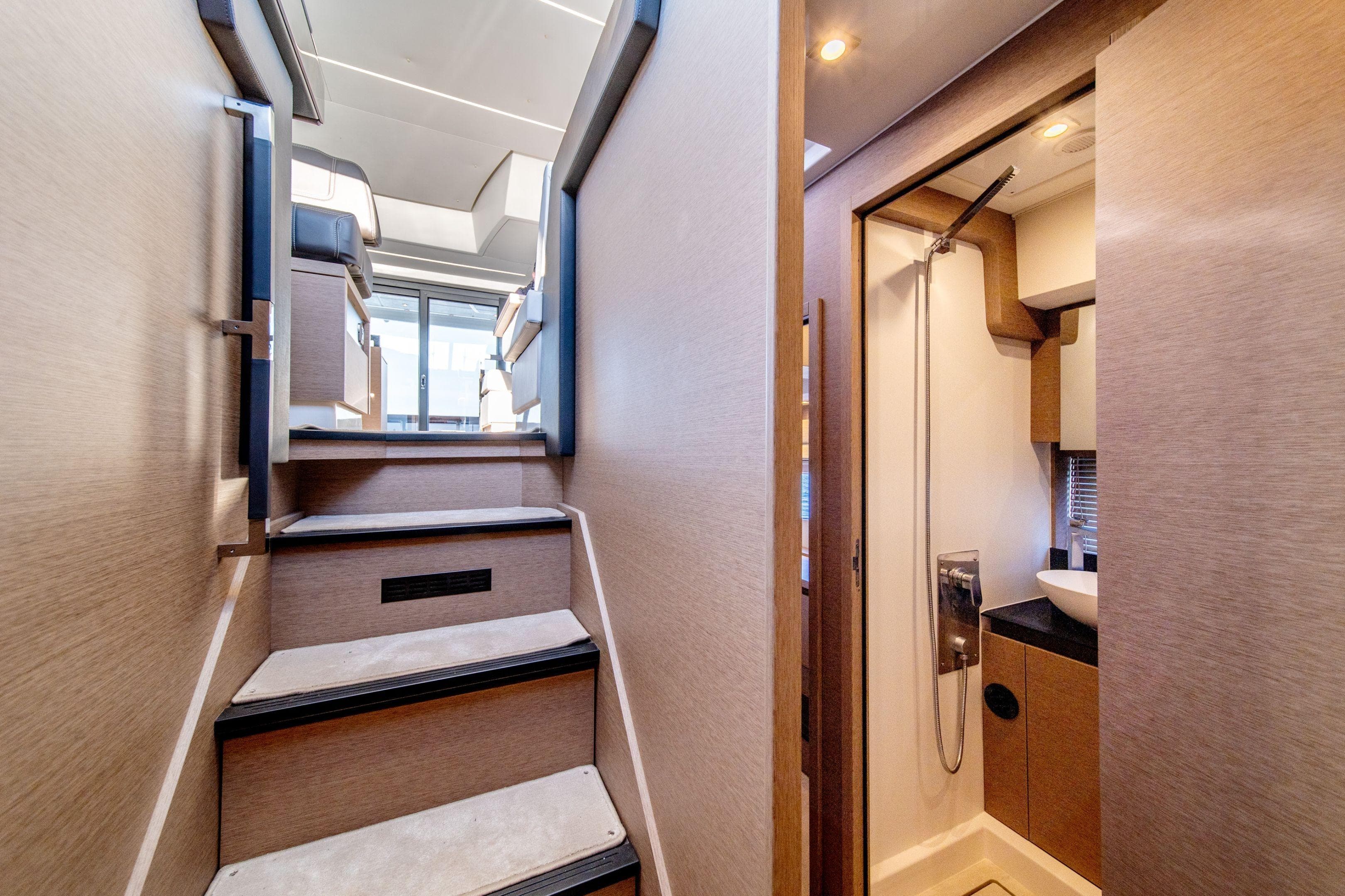 Interior view of 2026 Prestige 460 yacht, featuring stairs and a compact bathroom.