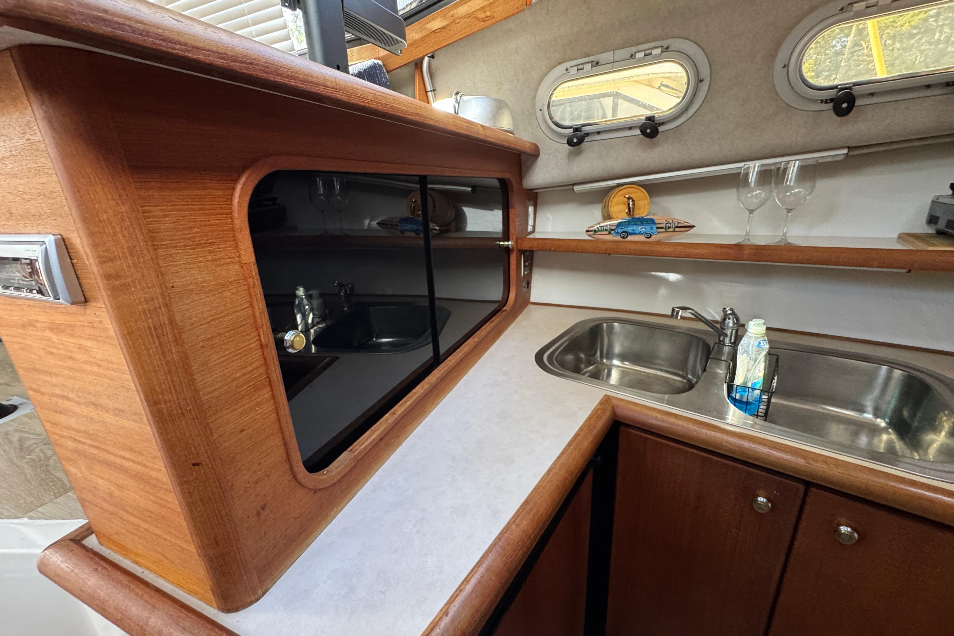 Interior of 1995 Bayliner 3288 Motoryacht featuring a compact kitchen with sink and storage.