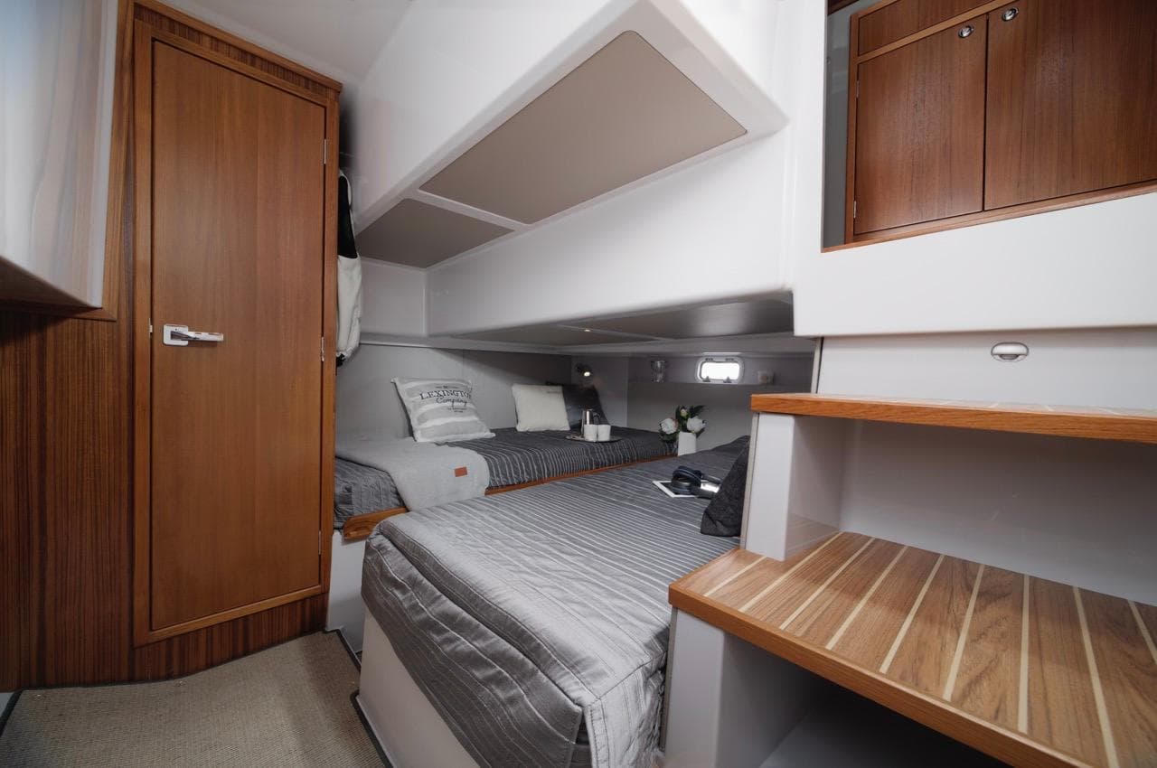 Interior of 2025 Sargo 33 boat cabin with twin beds and wooden accents.