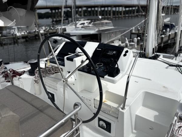 Helm of 2012 Lagoon 560 yacht with marina background.