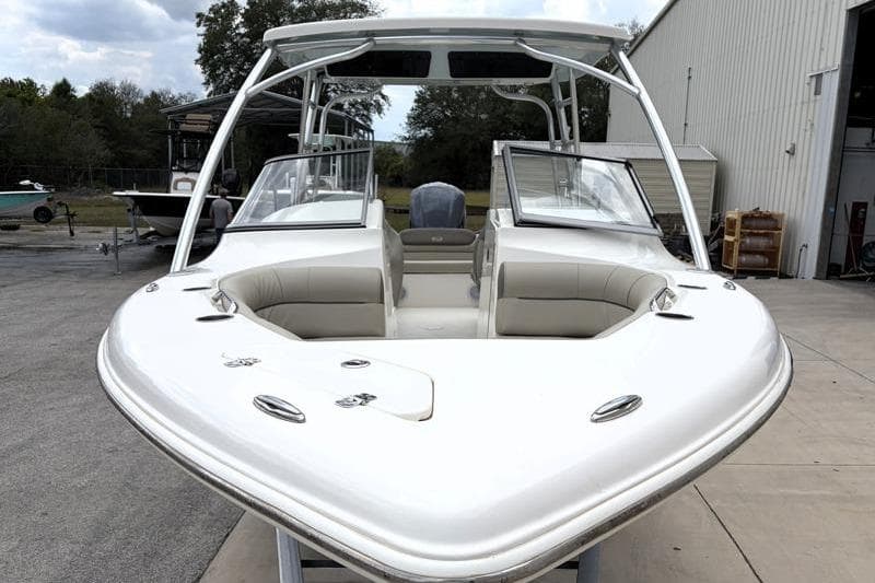 2024 Key West 239 DFS boat with open bow seating, docked near a warehouse.